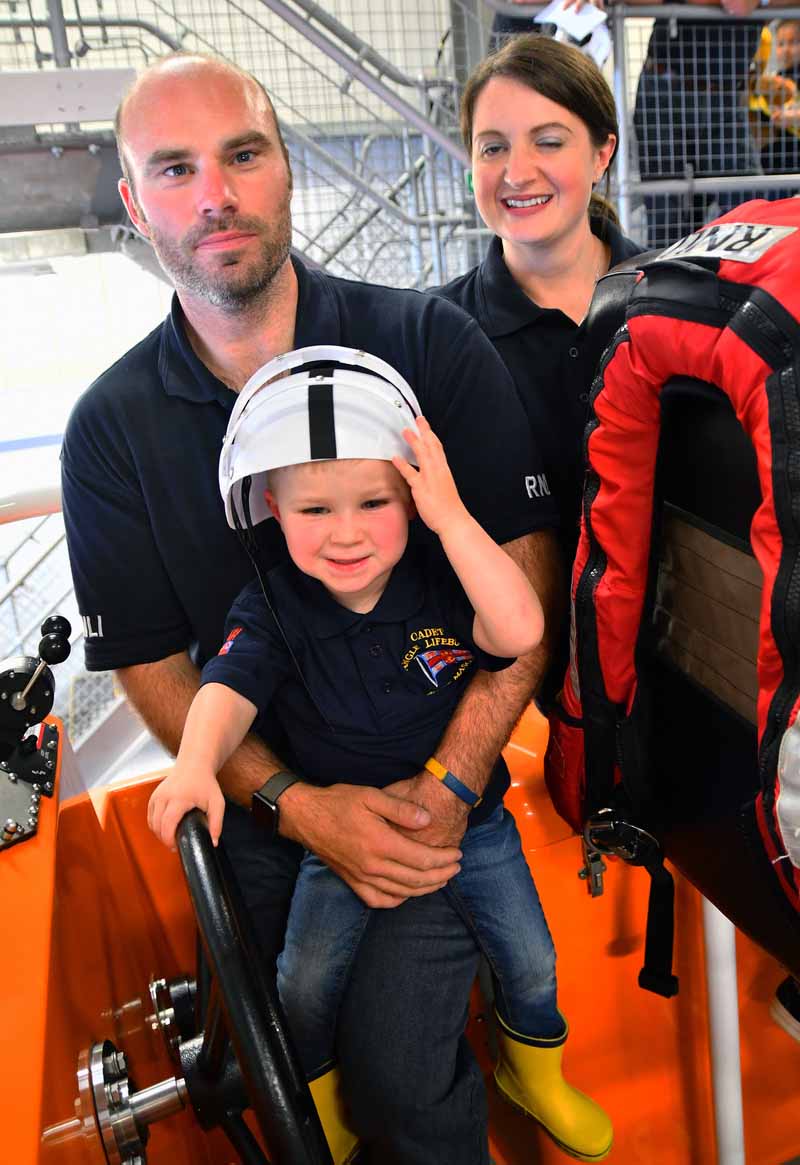 Coxswain Lewis Creese and partner Rhiannon Tebbutt, Crew Member, with their son Luke at the helm of Angle RNLI’s all weather lifeboat at the open day.