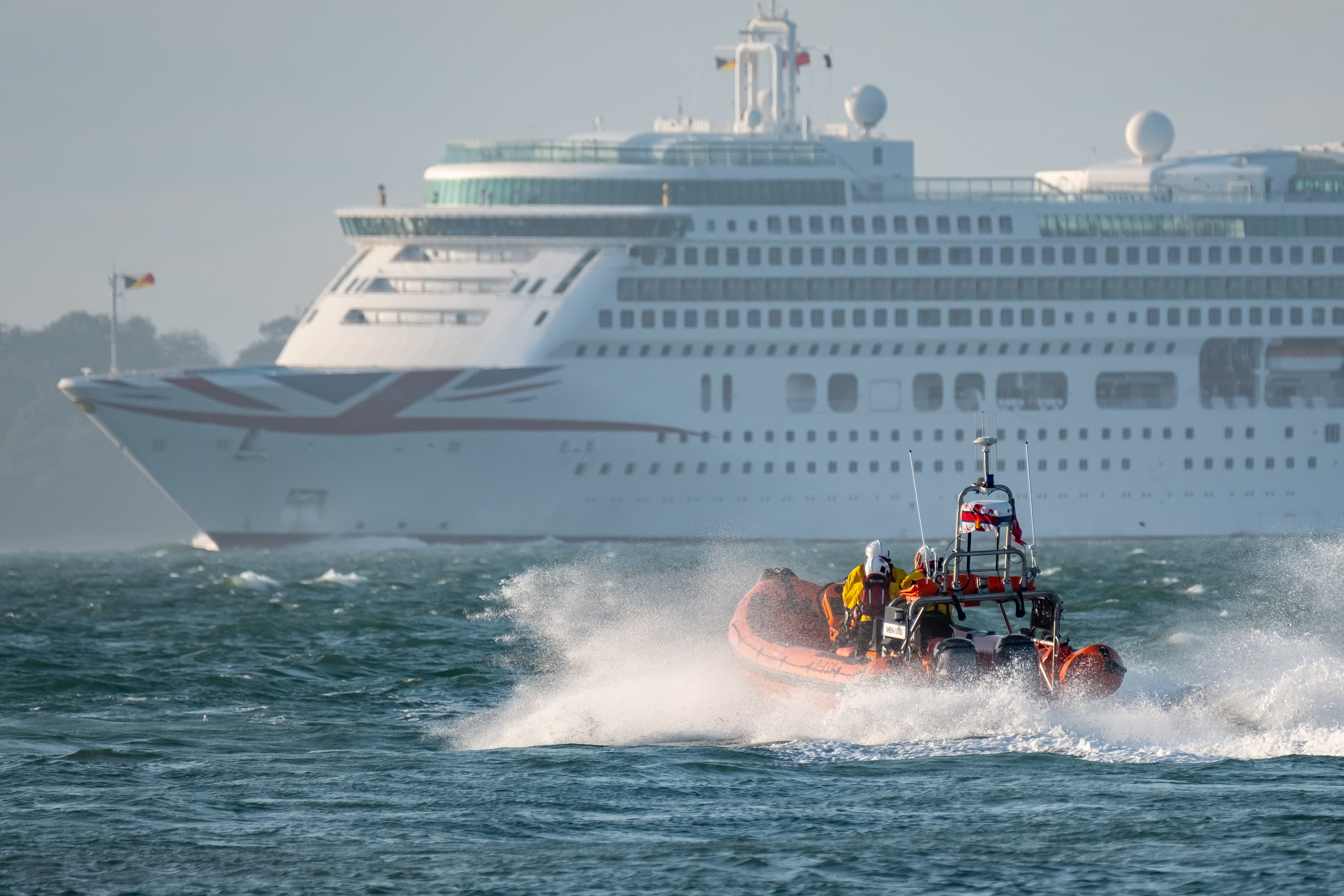 Cowes lifeboat, with cruise liner Aurora in the background, begins search for the speed boat.