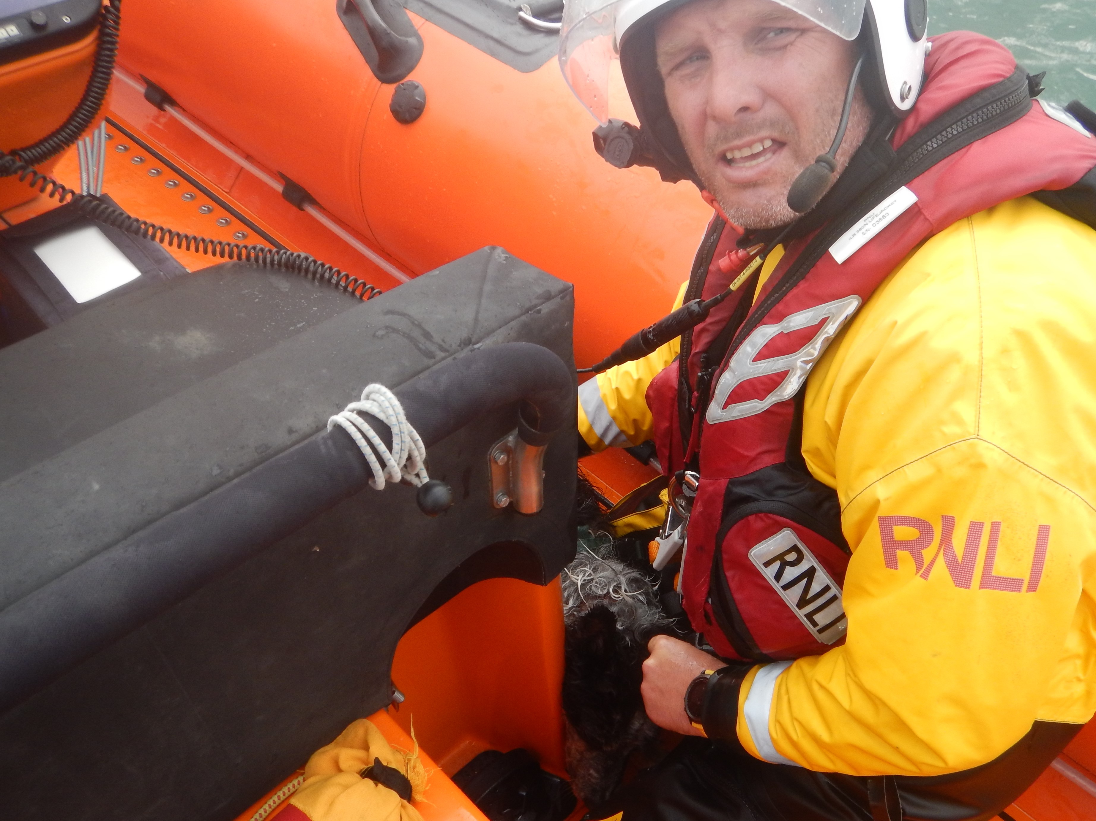 Mark Harker, Helm, with the rescued dog by his knee. 
