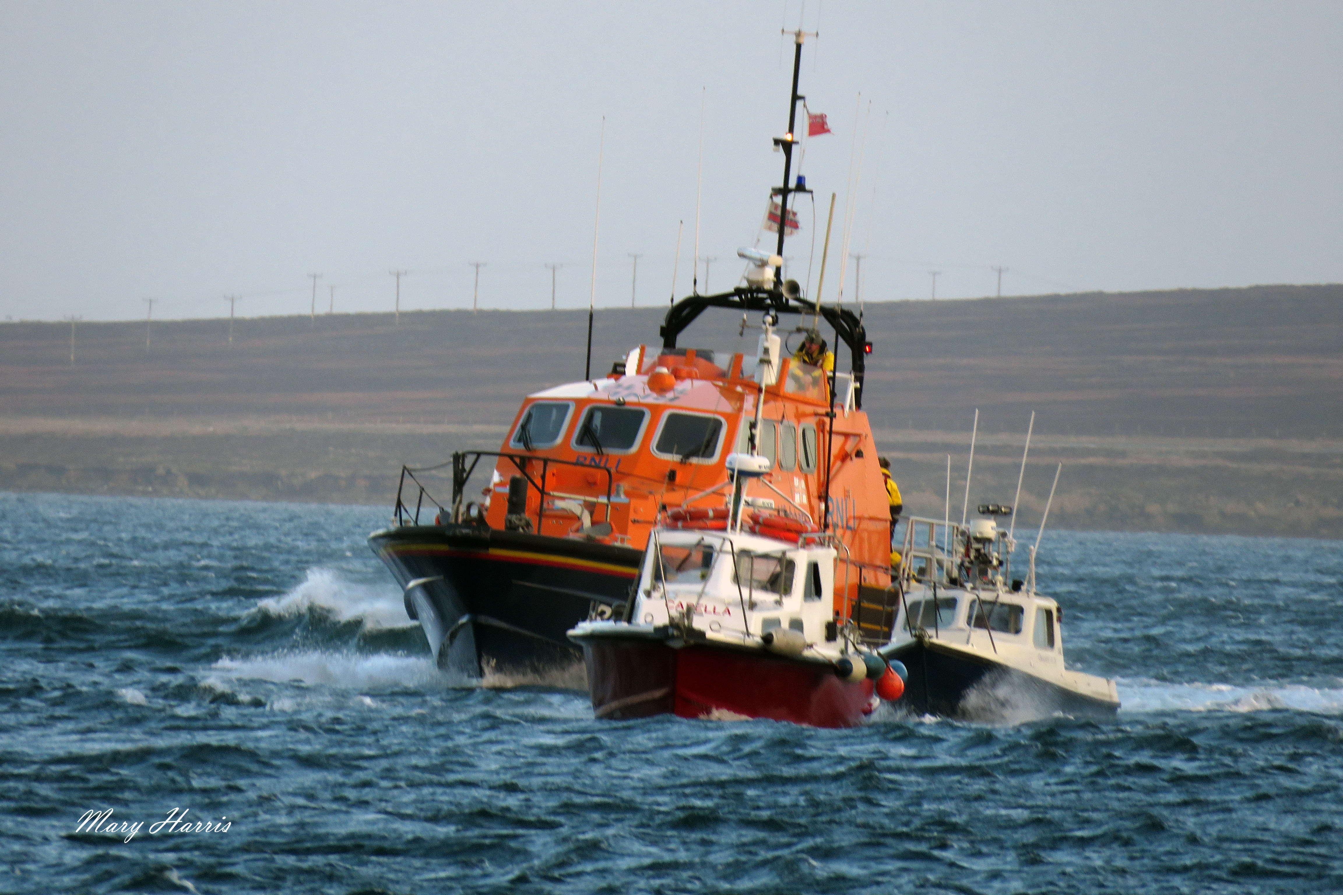 RNLI Longhope lifeboat escorting the vessels in tow back to Longhope pier