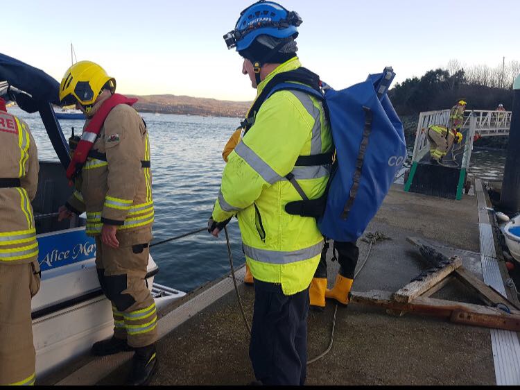 Firefighters and coastguards seen inspecting the casualty vessel from the pontoon.