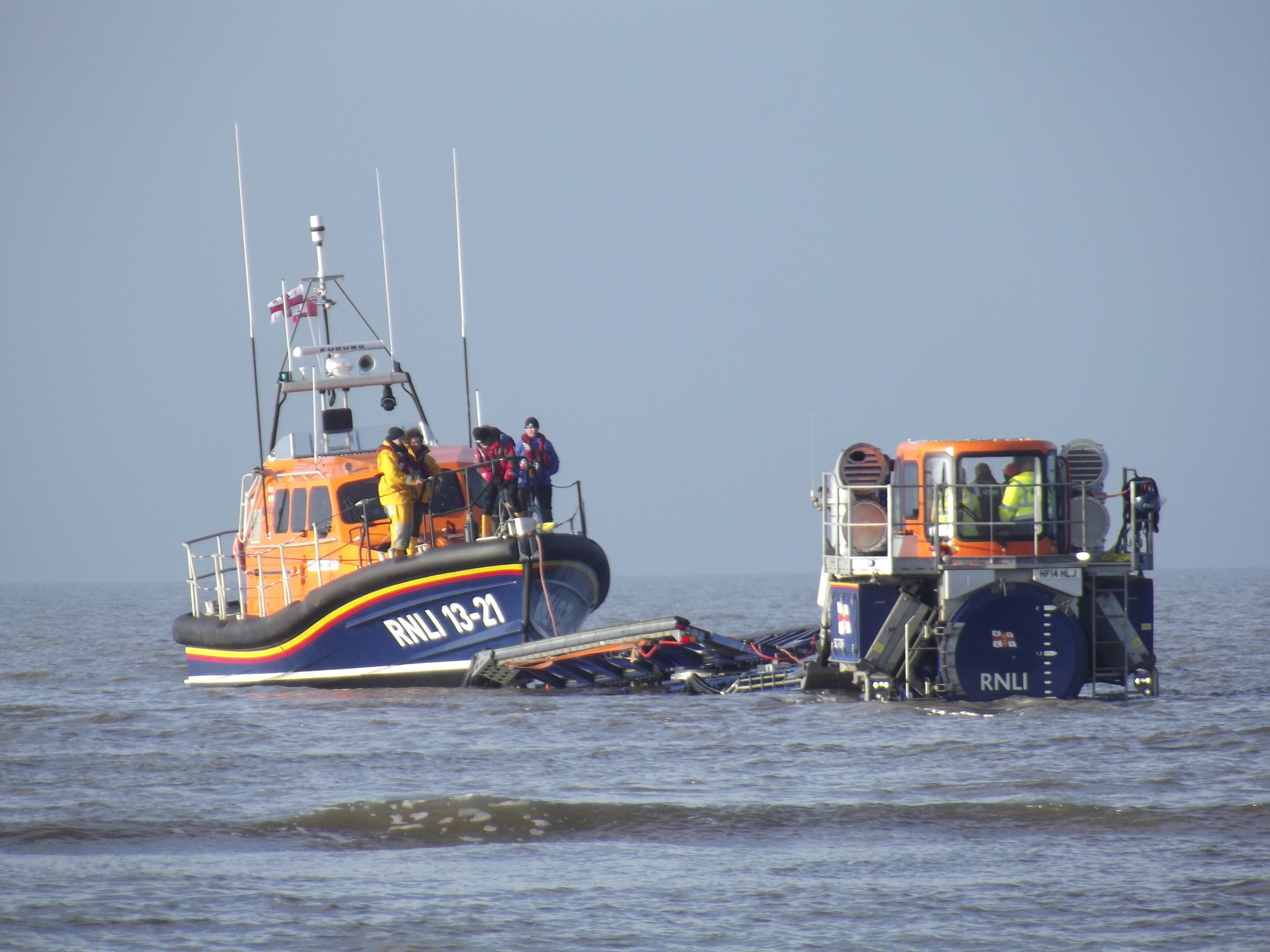 A lifeboat is being recovered from the sea by a "tractor and carriage system"