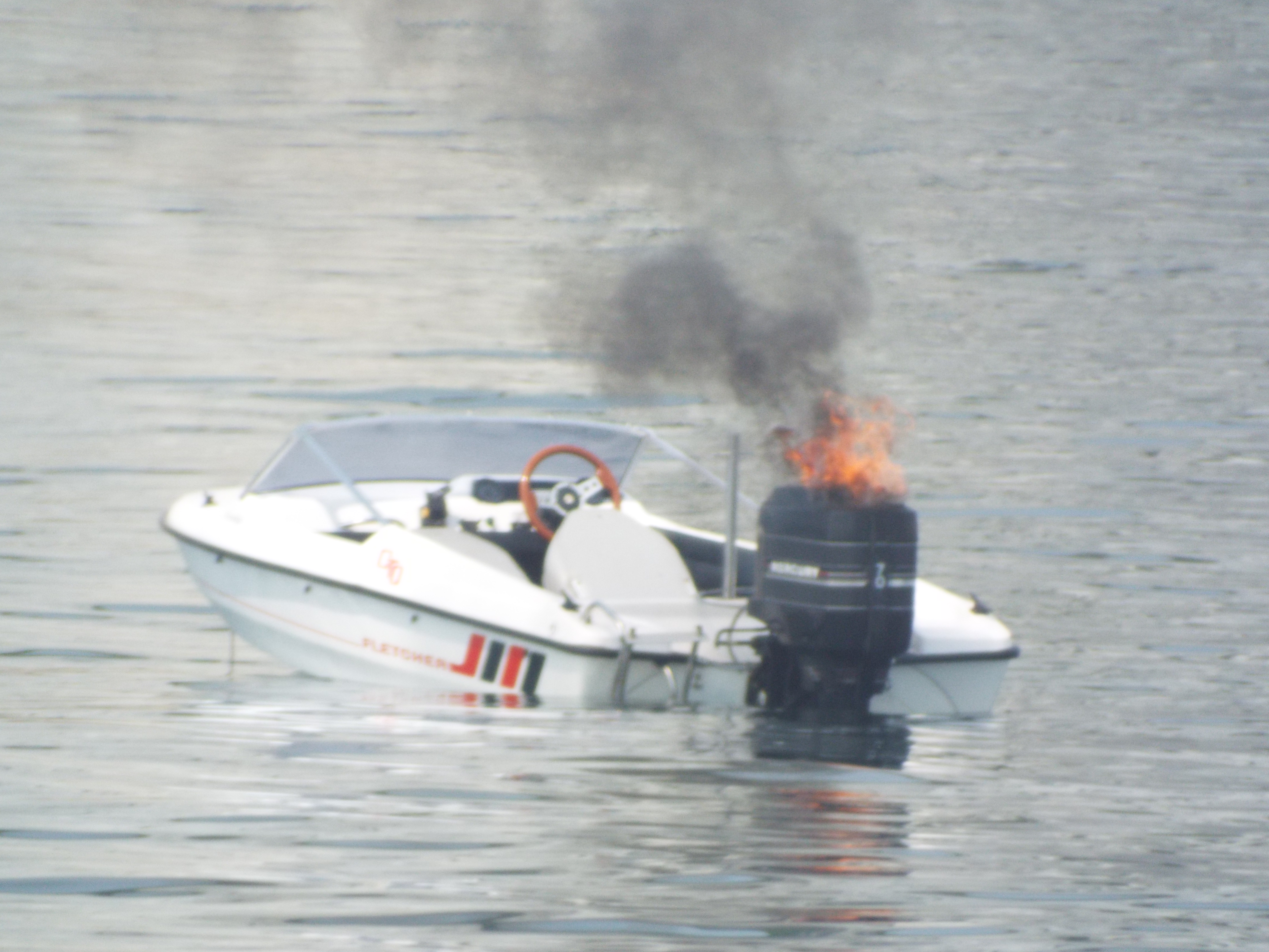Image of small powerboat on fire.