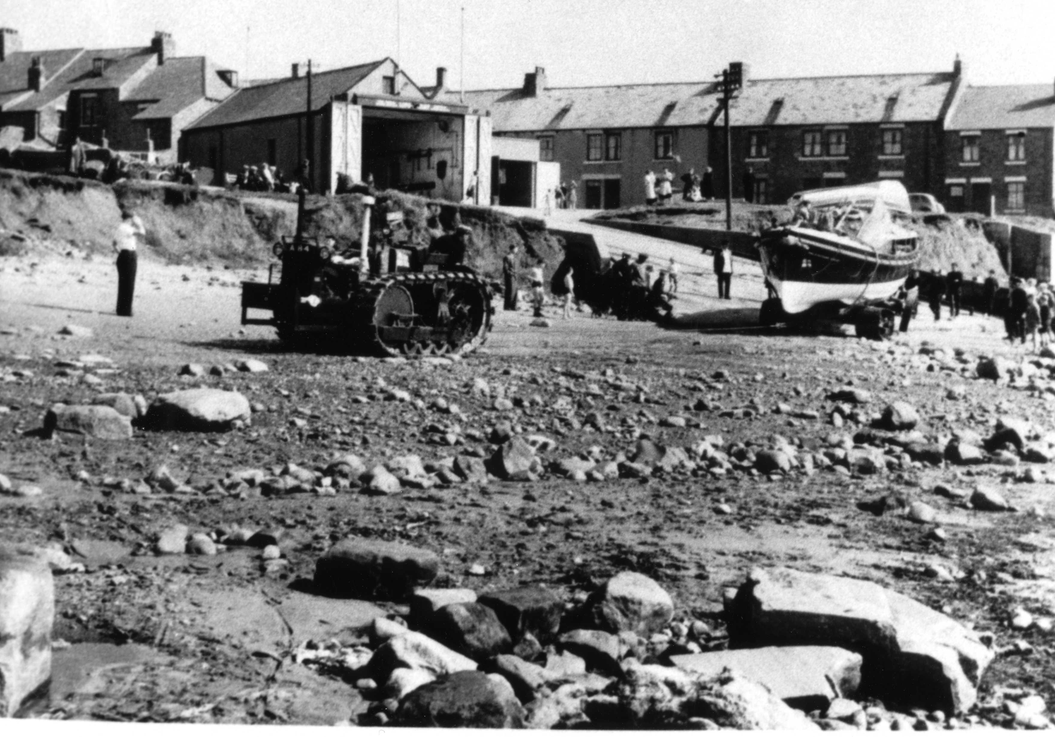 Newbiggin's lifeboat launching across a rockly foreshore