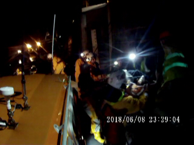 Peel RNLI volunteer crew working with paramedics and coastguards in helping a boy