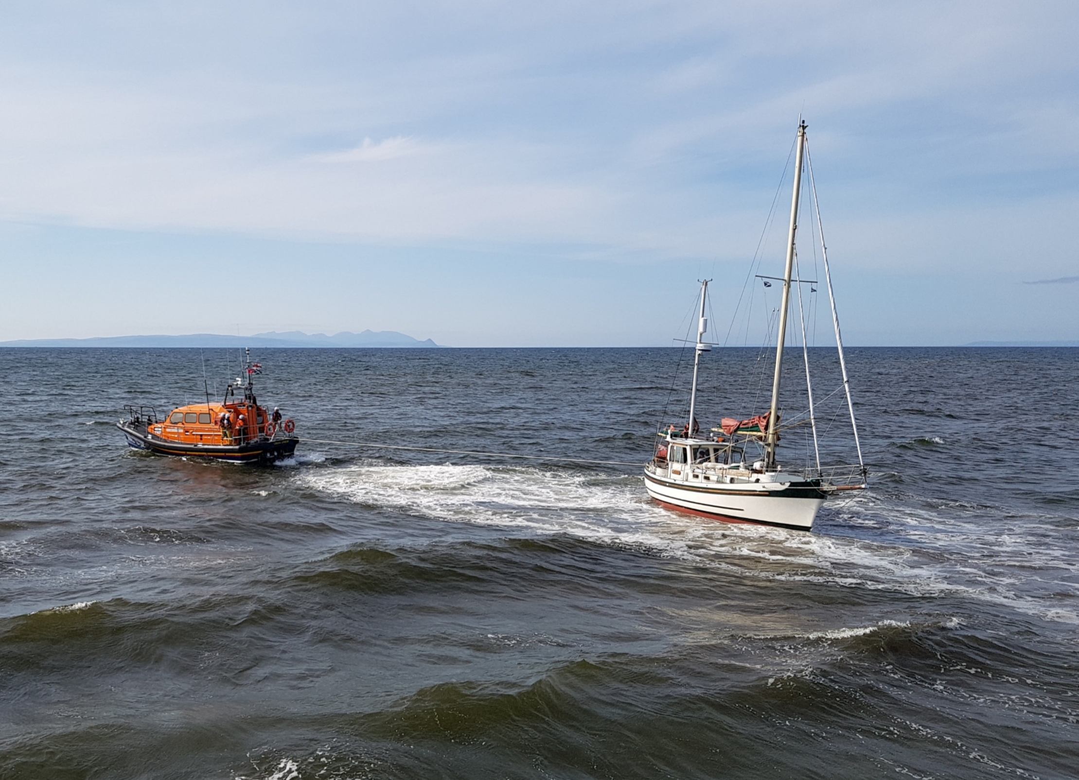 Girvan Lifeboat towing the yacht off the sand bar into the safety of deeper water.