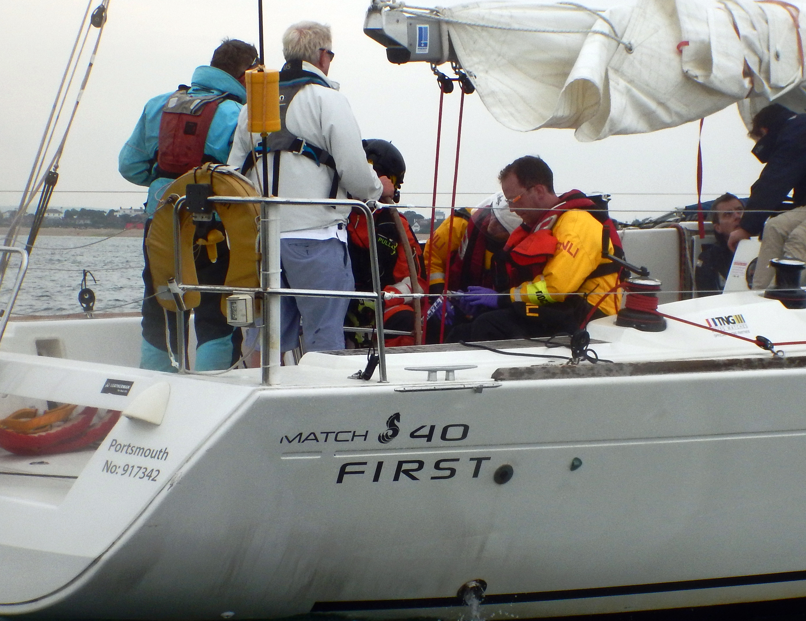 Showing crew members attending to sick yachtsman