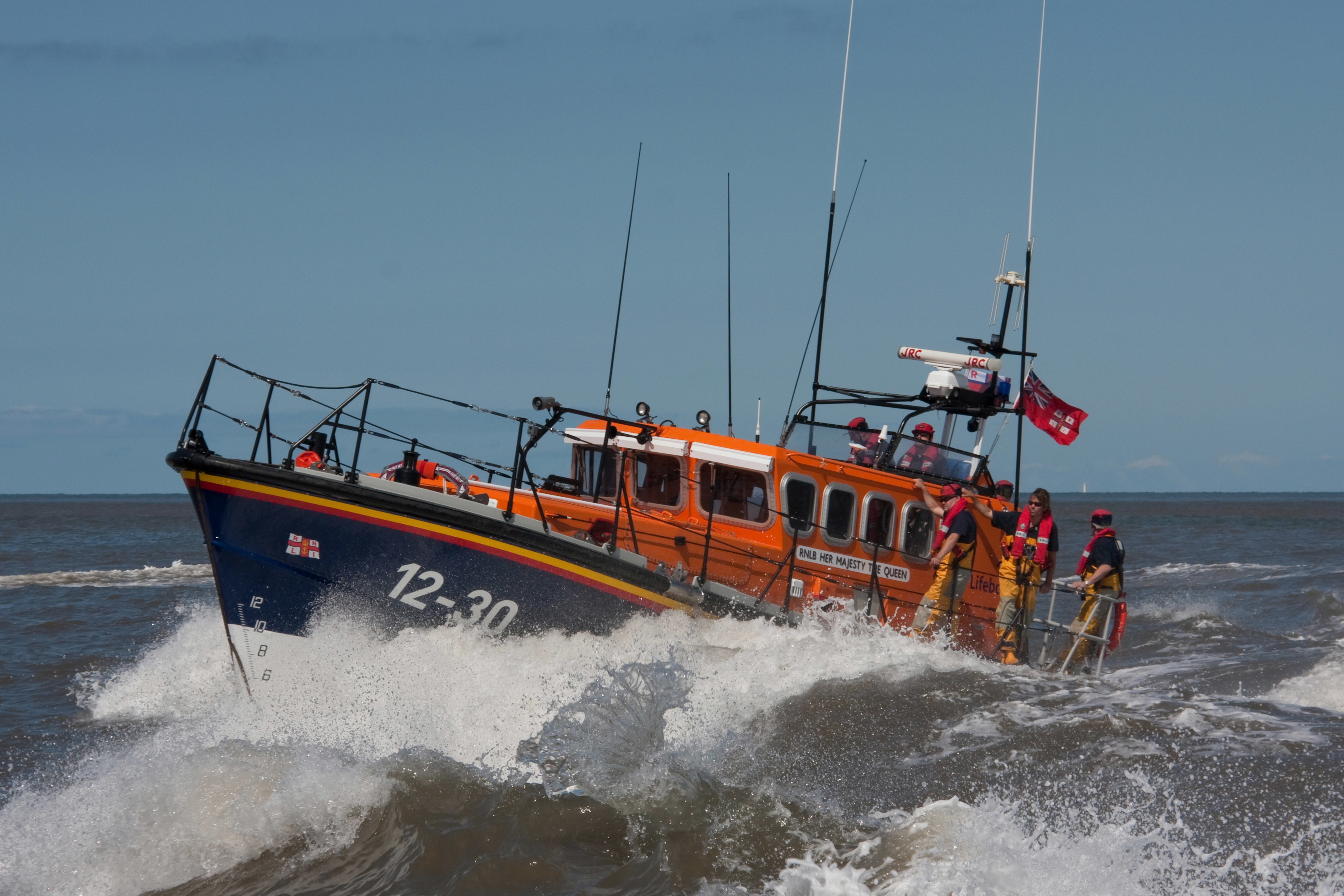a lifeboat crests the top of a wave 