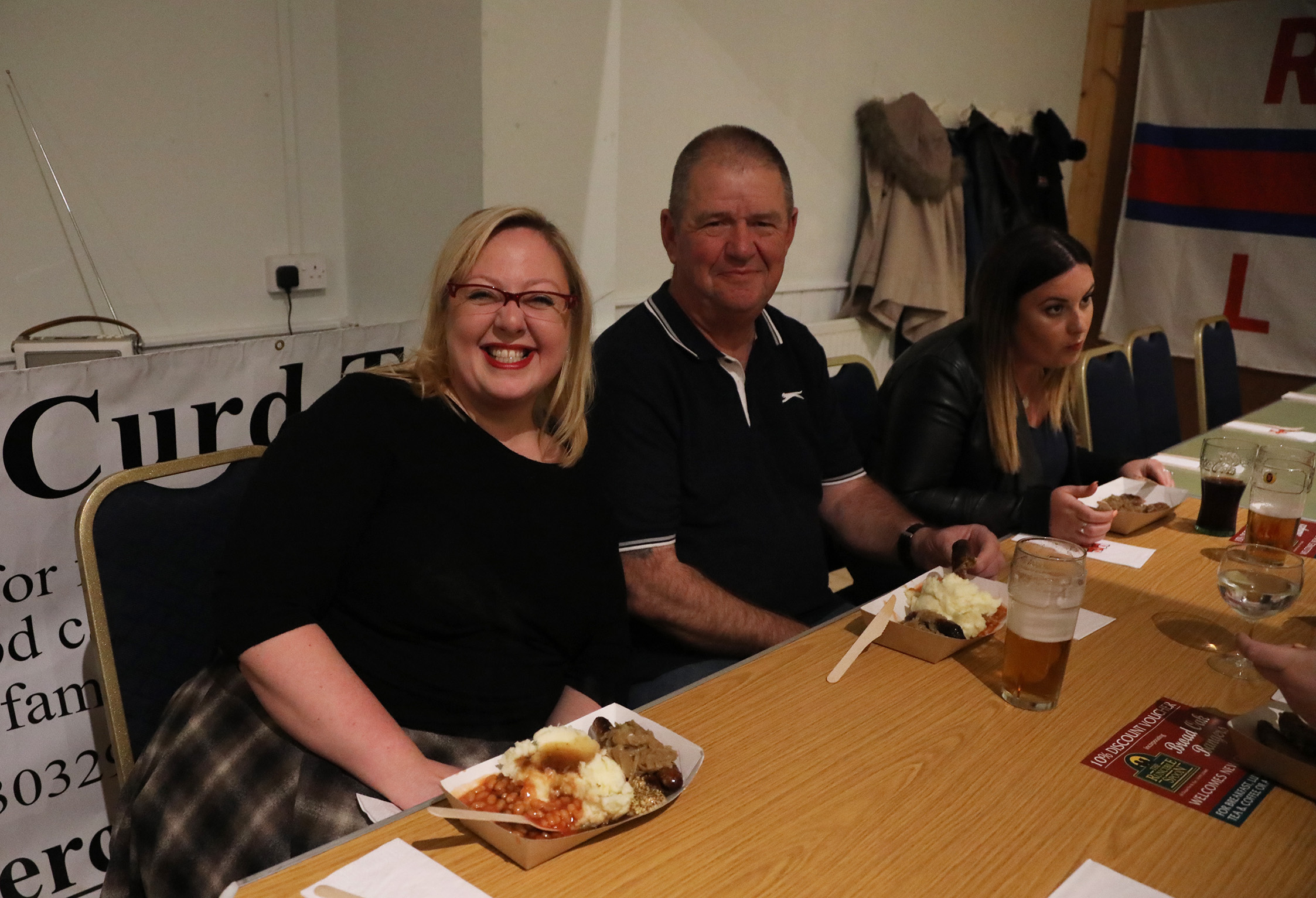 People sitting at a table just about to start eating their bangers and mash