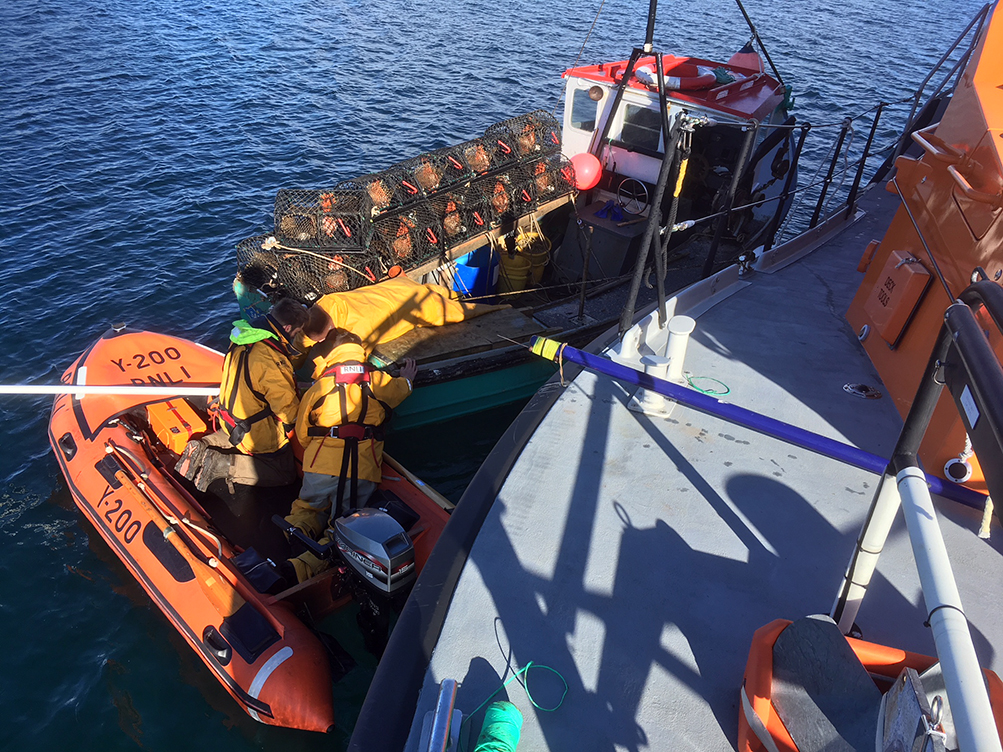 Longhope lifeboat crew members aboard Y boat working to free propeller
