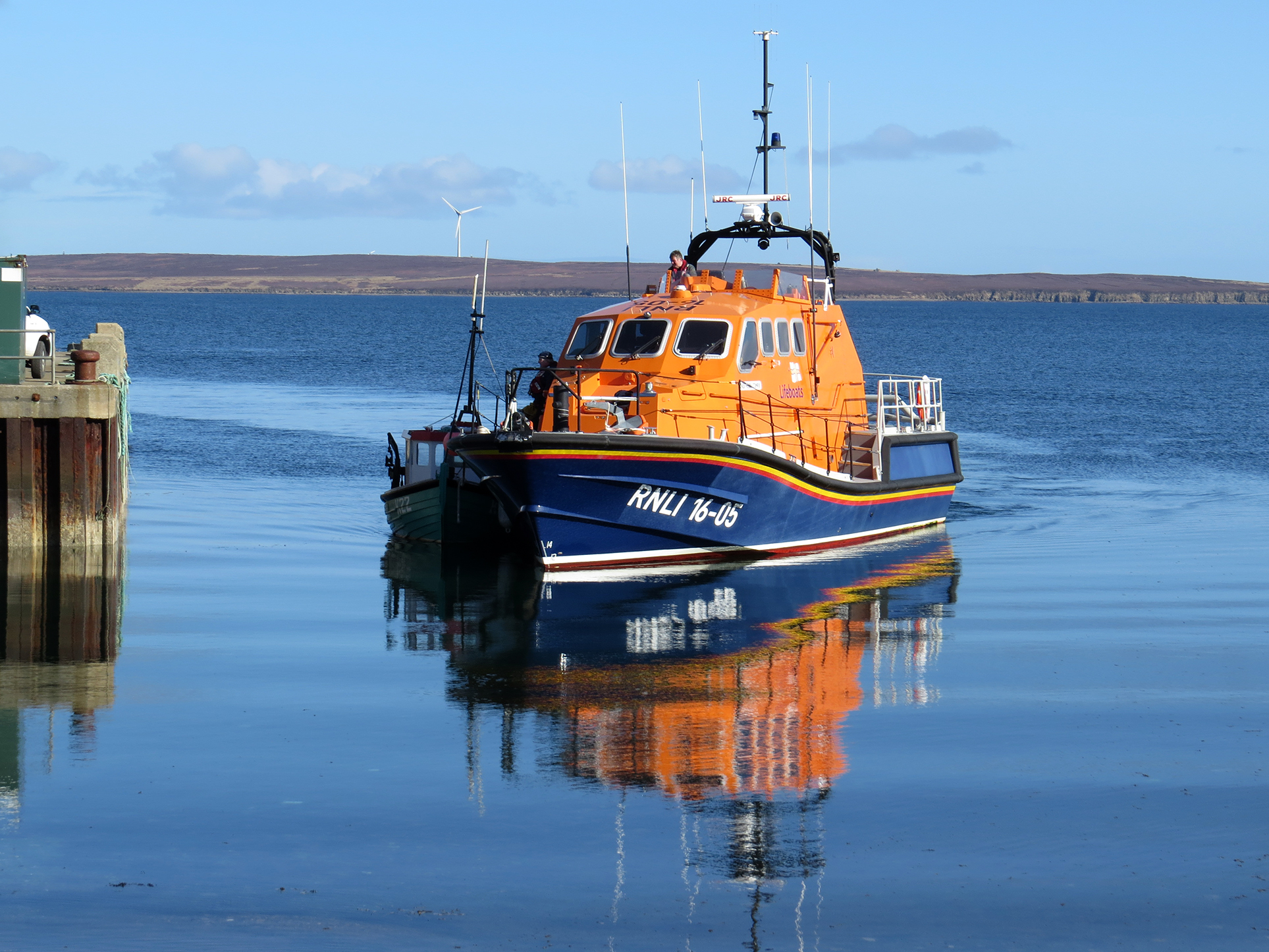 Longhope lifeboat safely bringing casualty vessel alongside Longhope pier