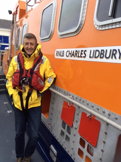 RNLI Aith new Coxswain standing beside RNLI Charles Lidbury
