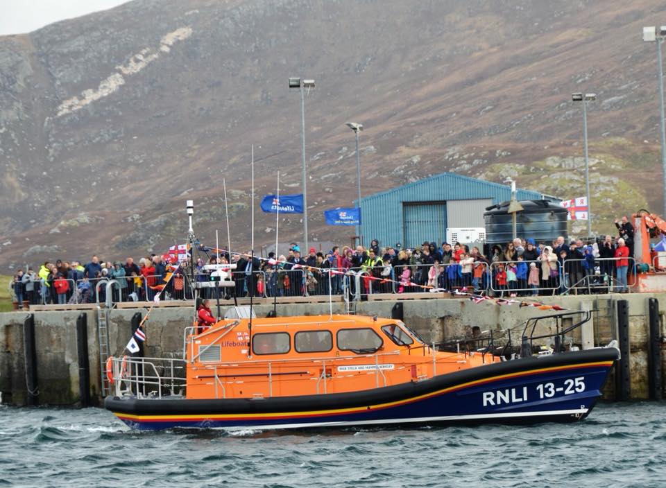 RNLB Stella and Humfrey Berkeley 13-25 beside large crowd of people on Leverburgh pier