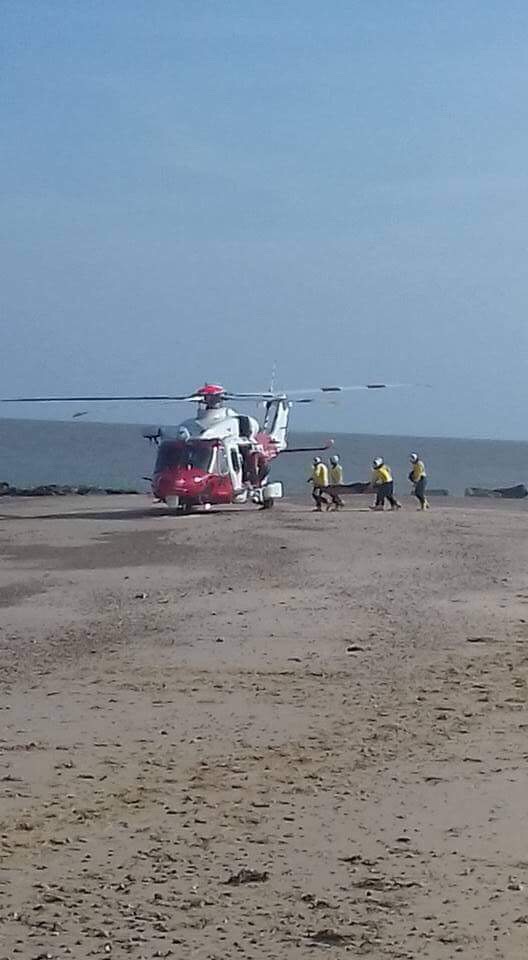 Volunteer crew help transfer casualty to helicopter