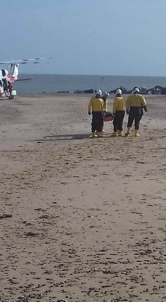 Volunteer crew help transfer casualty to helicopter