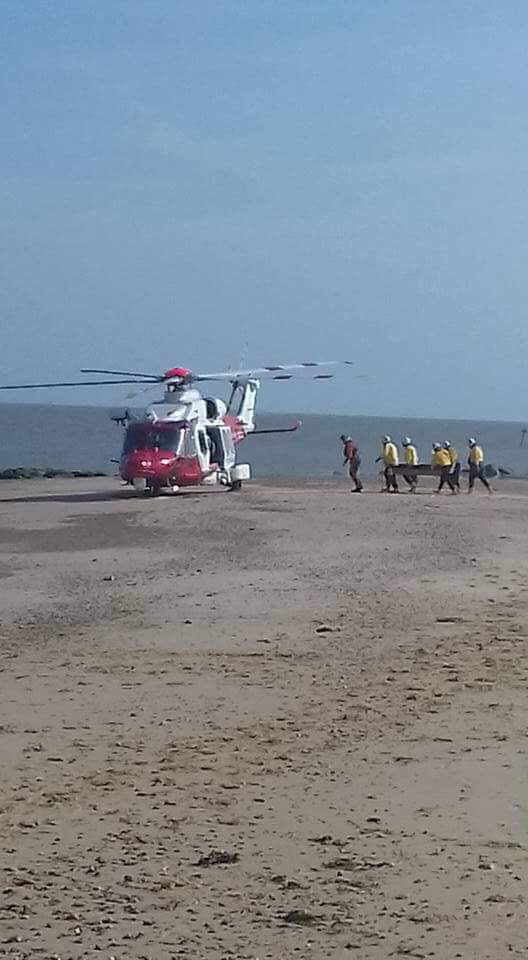 Volunteer crew help transfer casualty to helicopter