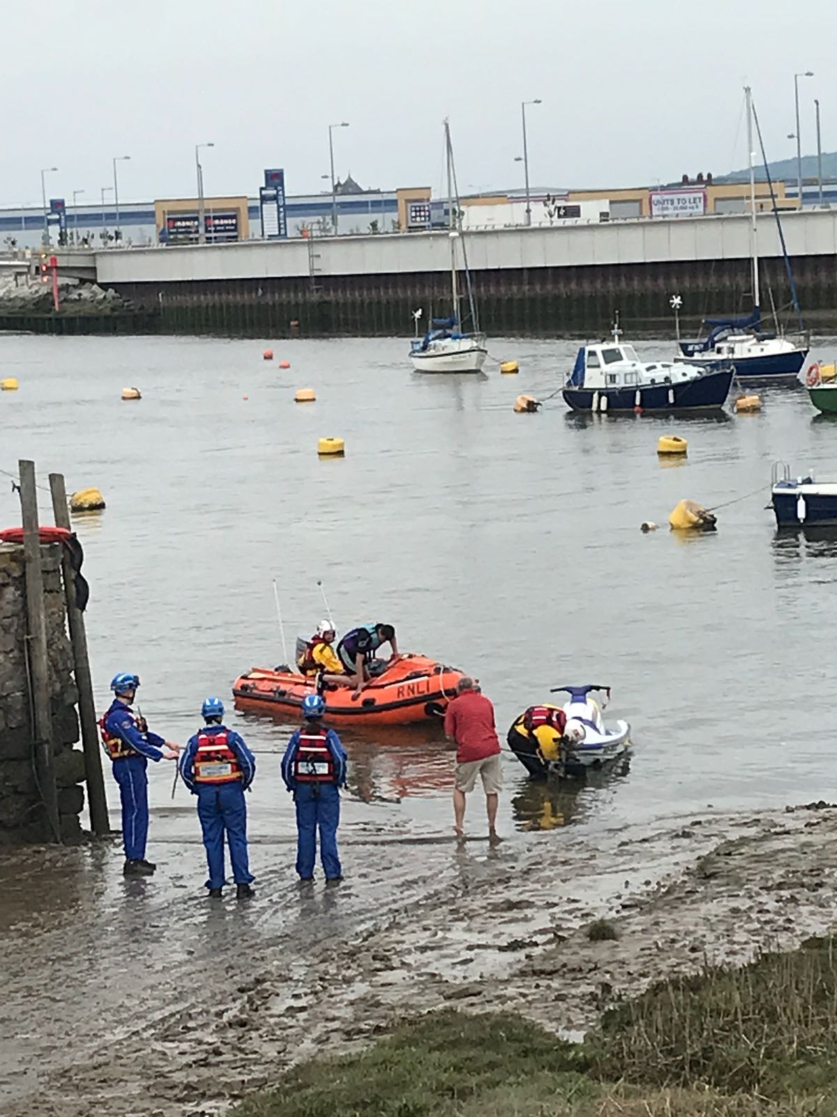 coastguards meet RNLI crew and jetski at Rhyl harbiour after the vessel runs out of fuel.