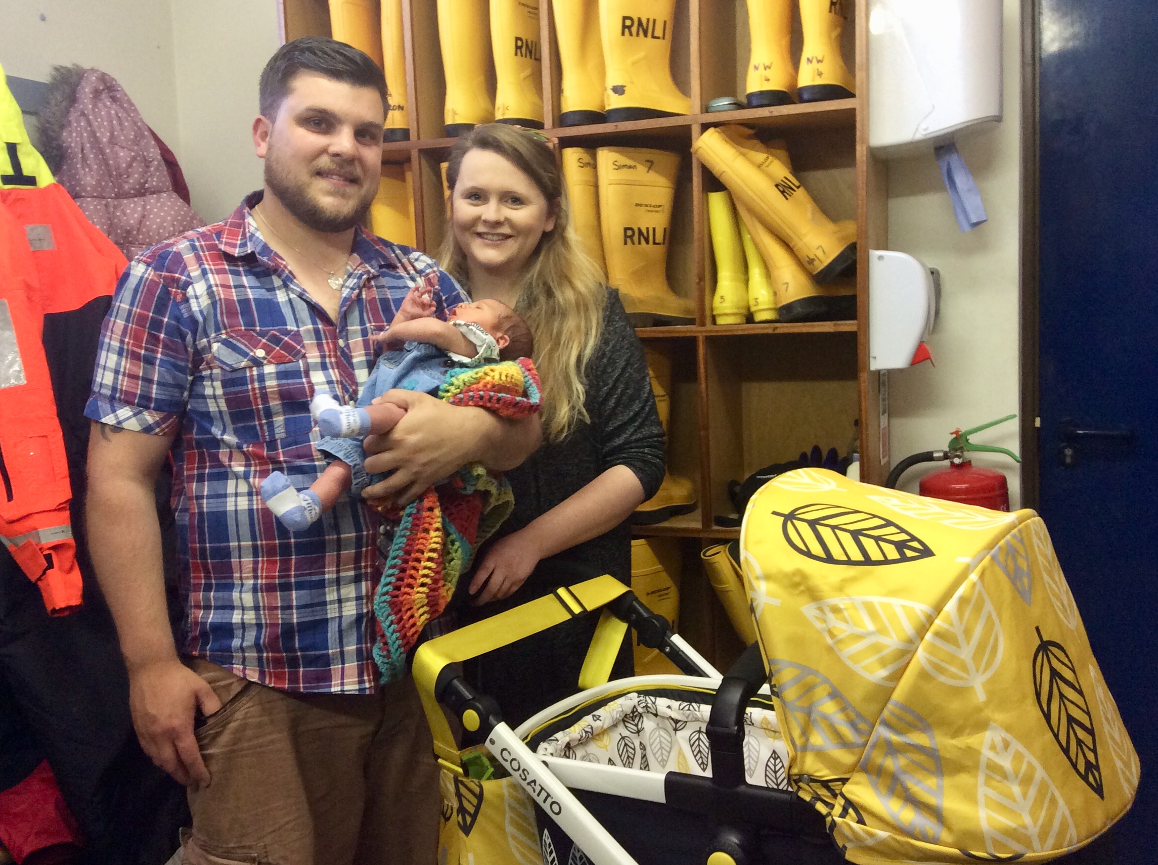 The bright yellow pram in front of the yellow wellies.
