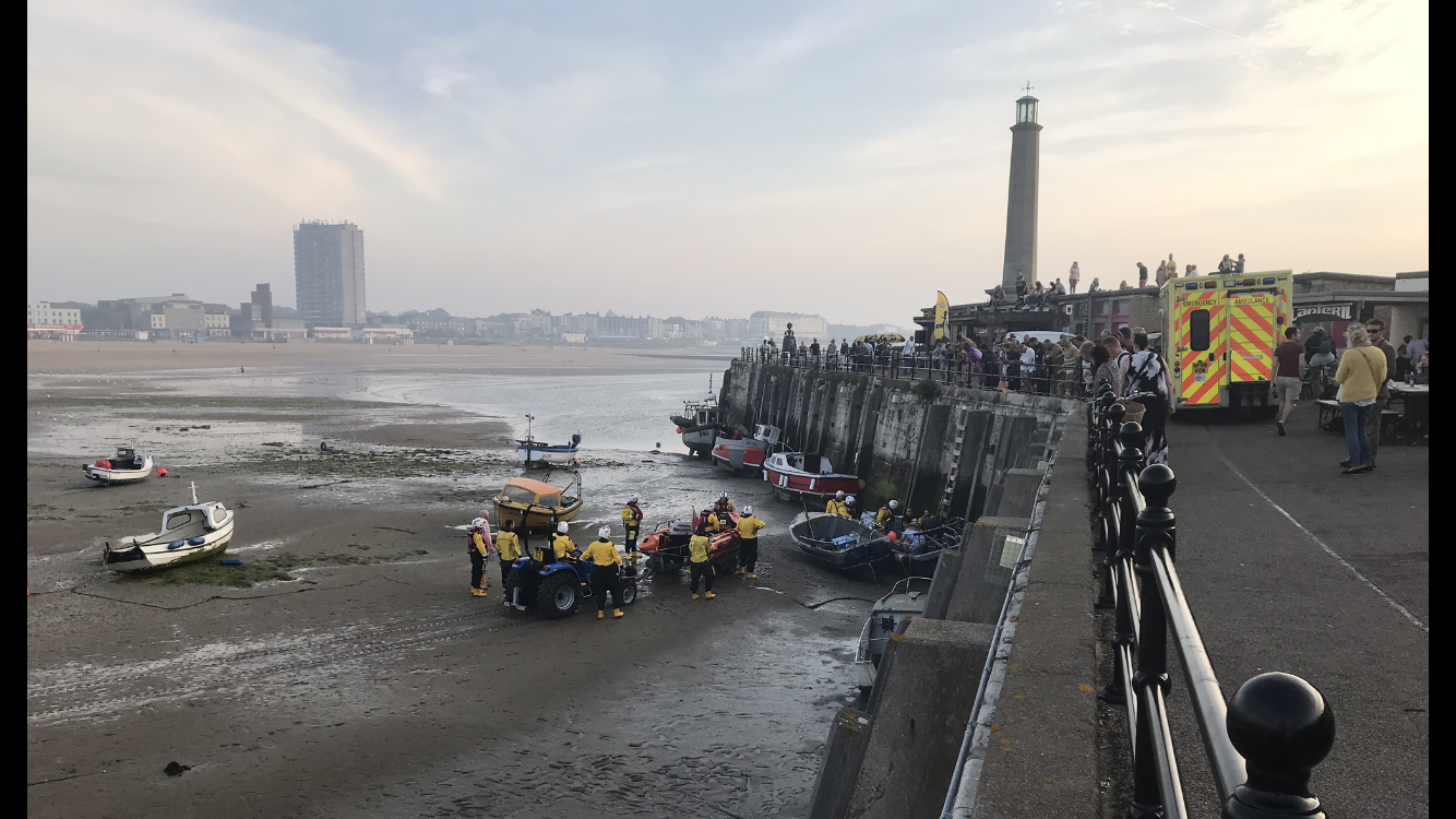A sobering picture of how the work of our volunteer lifeboat crew is not always restricted to actually being at sea. Taken on Monday evening by Stuart Cattell, one of our crewmen and a RNLI Lifeguard Supervisor it shows the lifeboat crew assisting SECAMB paramedics after a female fell from the harbour wall at Margate. 