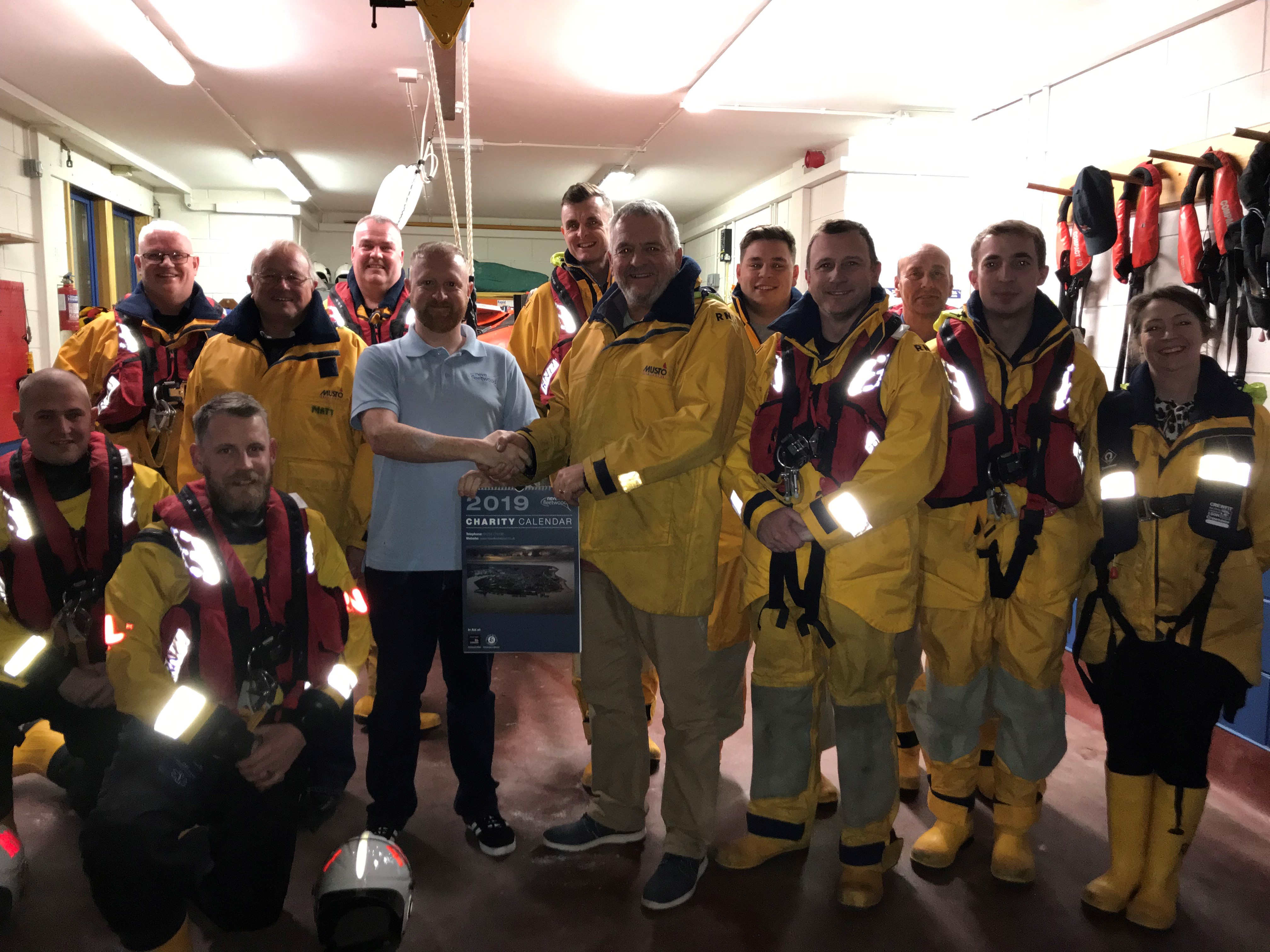 Jonathan Marr of Neve Fleetwood presenting the charity calendat to Capt. David Eccles with the lifeboat crew