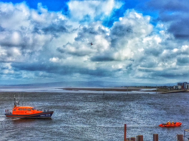 Both Fleetwood RNLI in-shore and all-waether lifeboats setting off from the lifeboat station with UKSAR 936 search helicopter above.