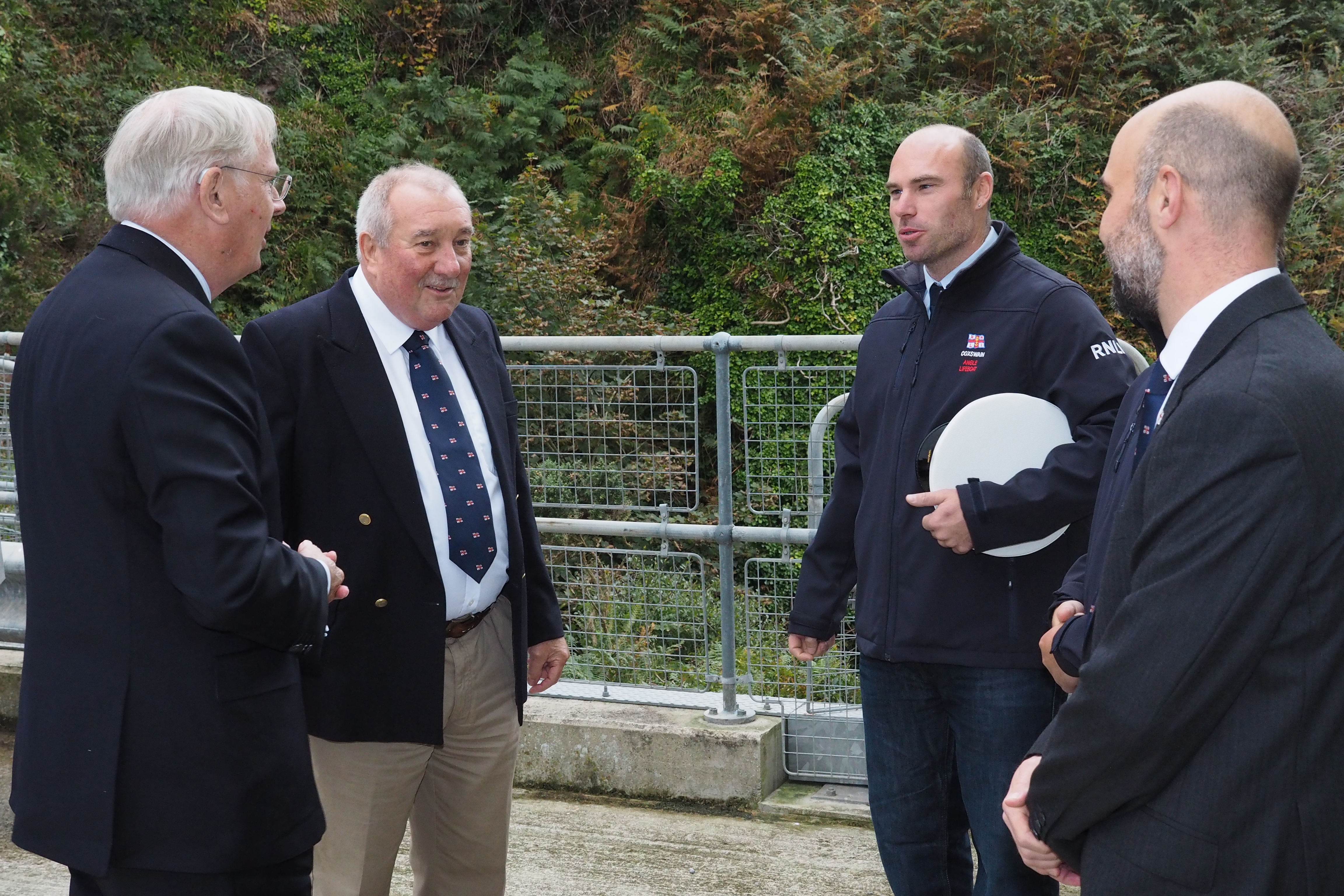 The Duke of Gloucester is welcomed by Angle RNLI’s Lifeboat Operations Manager Julian Hammond, Coxswain Lewis Creese and RNLI Regional Safety Manager Adam Forrest.