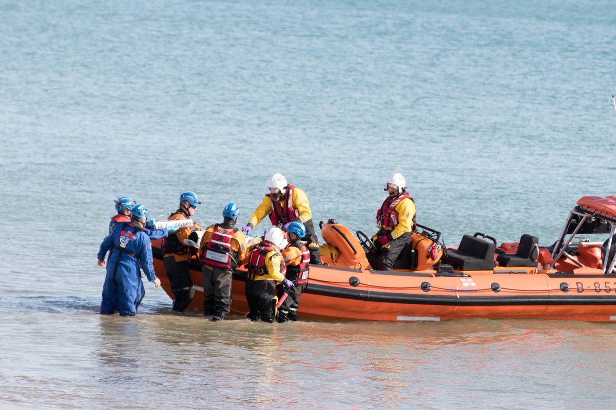 Photo fo the Atlantic 85 lifeboat from Brighton RNLI on the shore surrounded by emergency workers