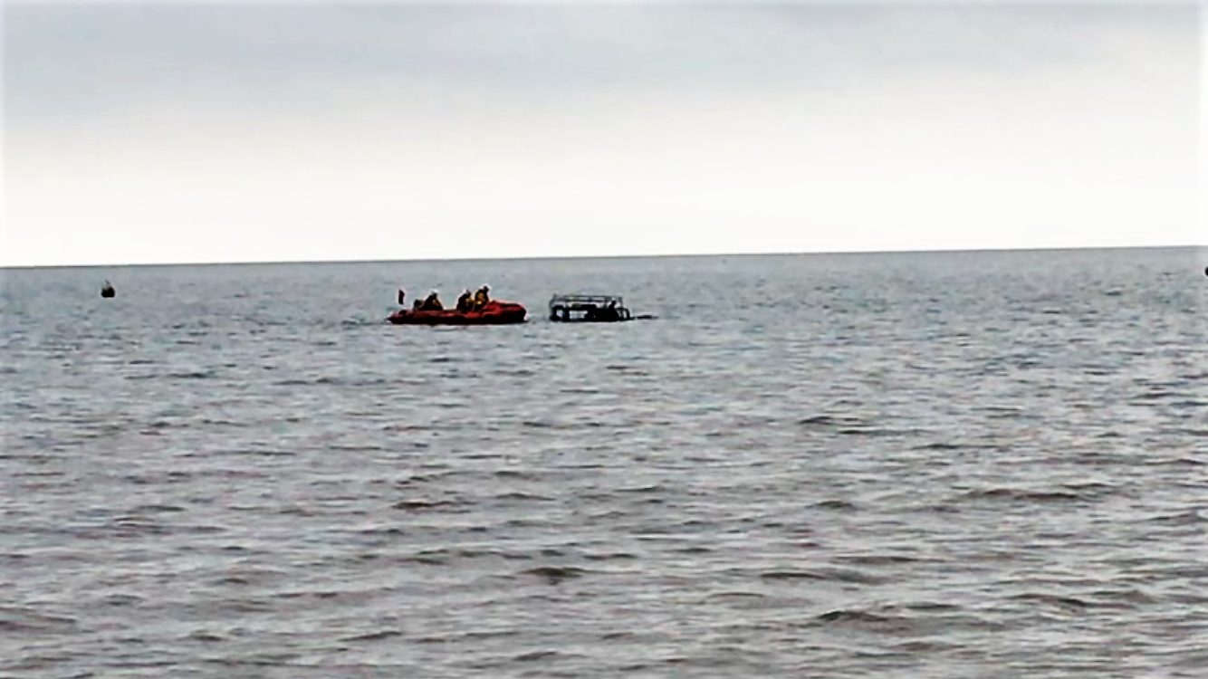 The lifeboat crew approaching the Landrover to release tow lines after attempts to rescue it had failed.