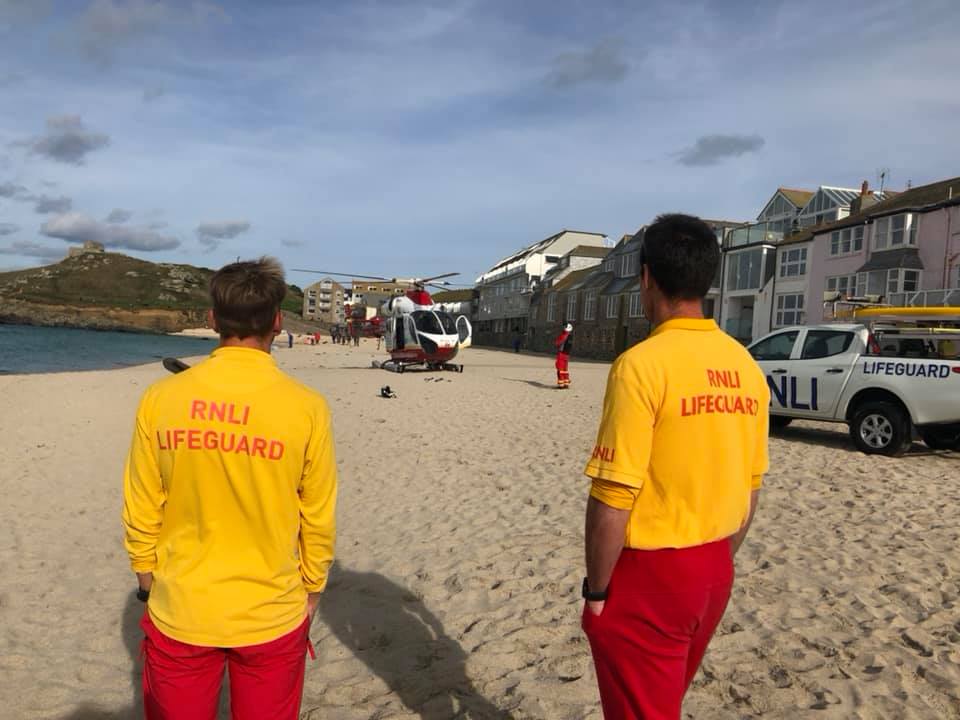 RNLI lifeguards at Porthmeor with the Cornwall Air Ambulance on the beach