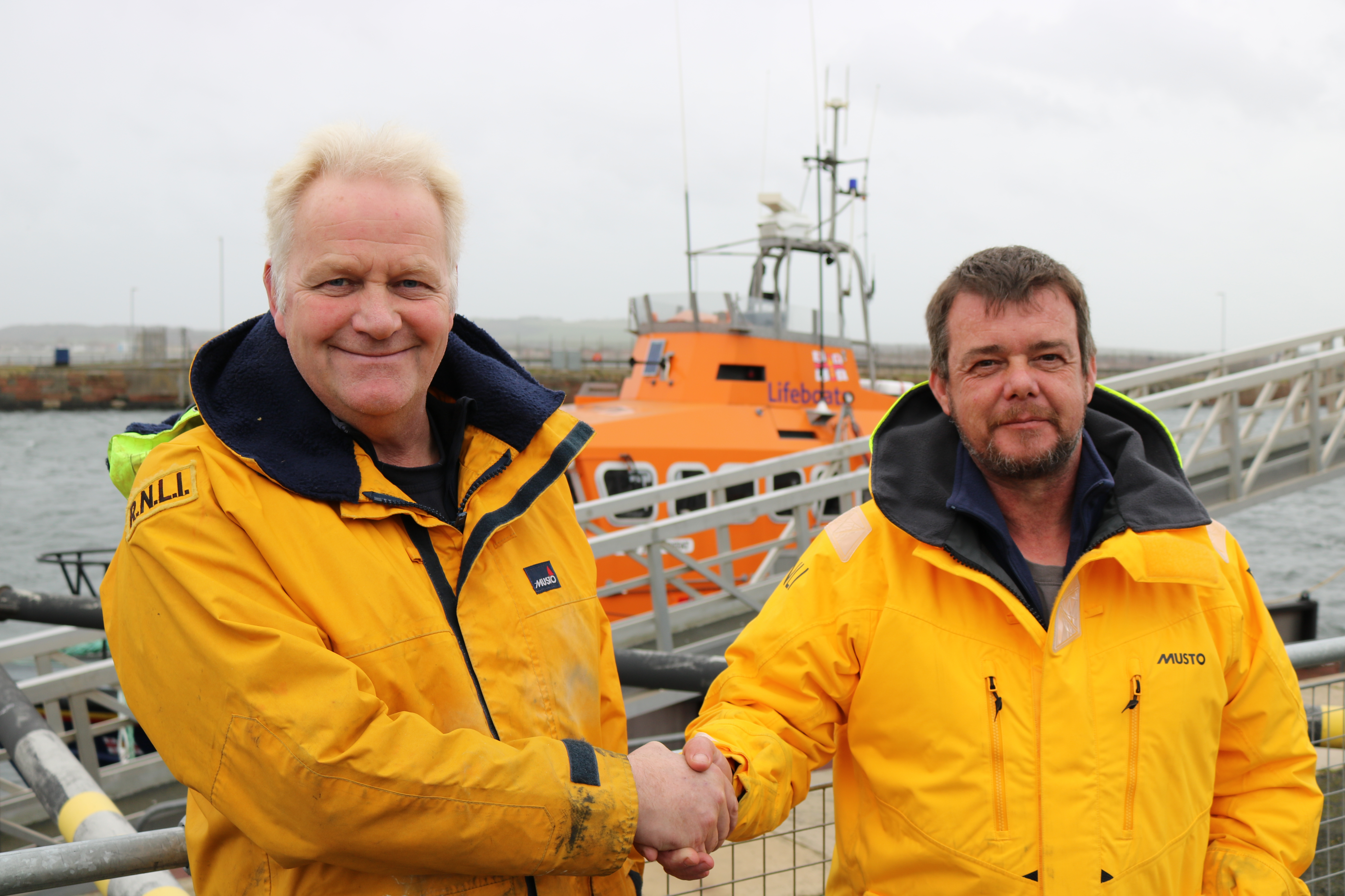 In fron tof Troon all-weather lifeboat Andrew Alston (left) hands over to new mechanic Evan Gallacher