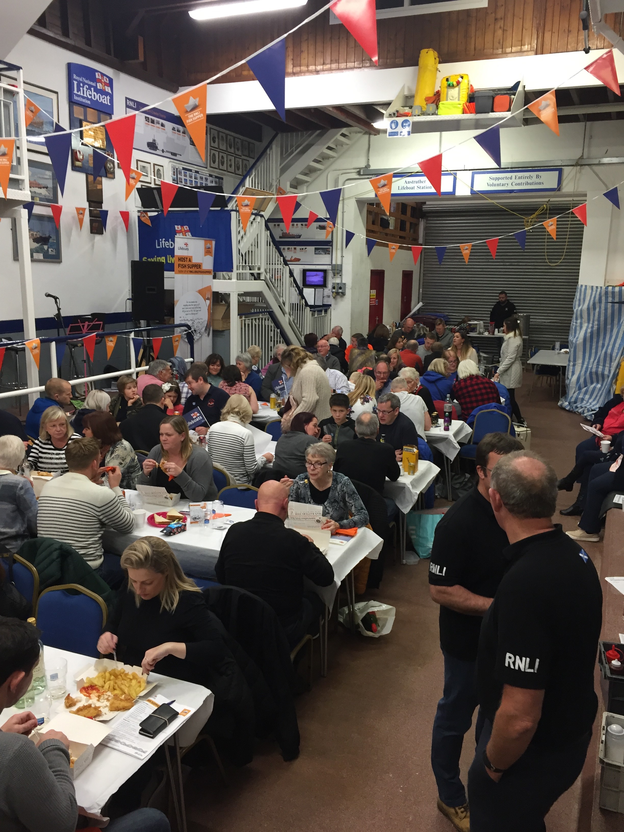 Supporters of RNLI Anstruther tuck into fish and chips in the boat shed