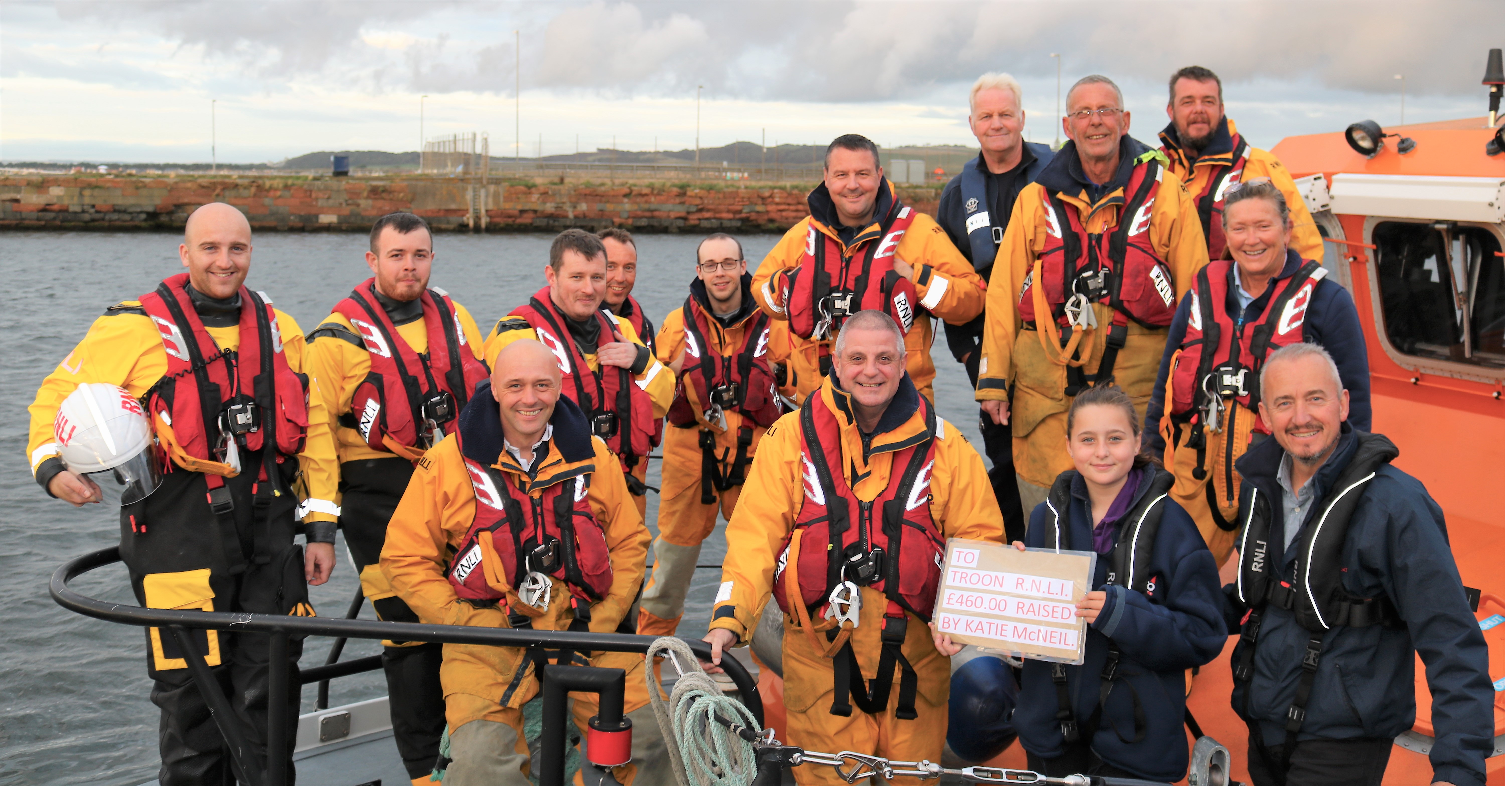 The Coxswain and crew aboard Troon all-weather lifeboat receiving the money raised from Katie and her dad Colin, a crewmember at Troon