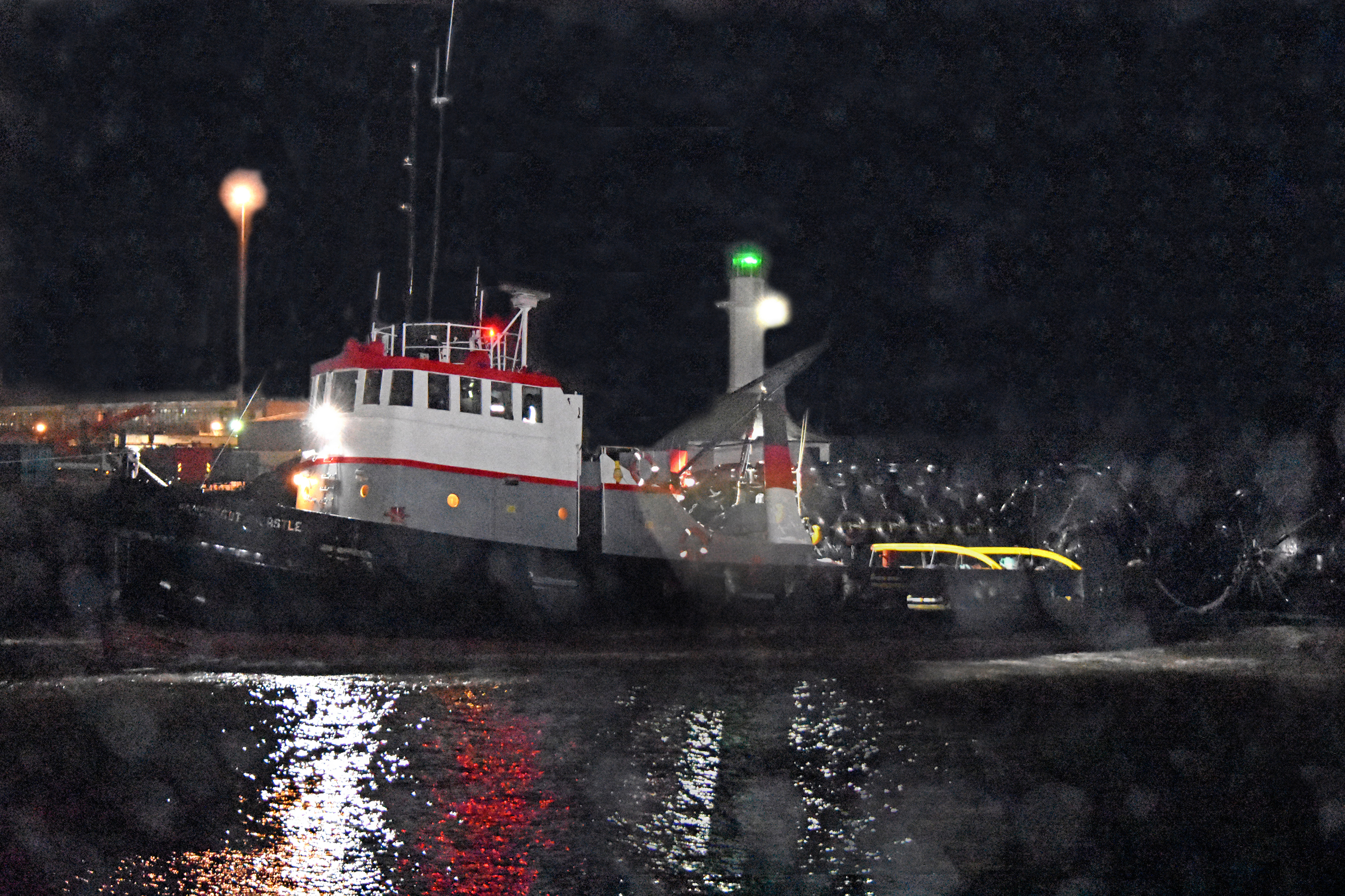 Tug and giant fenders pass through the pier heads at Lowestoft