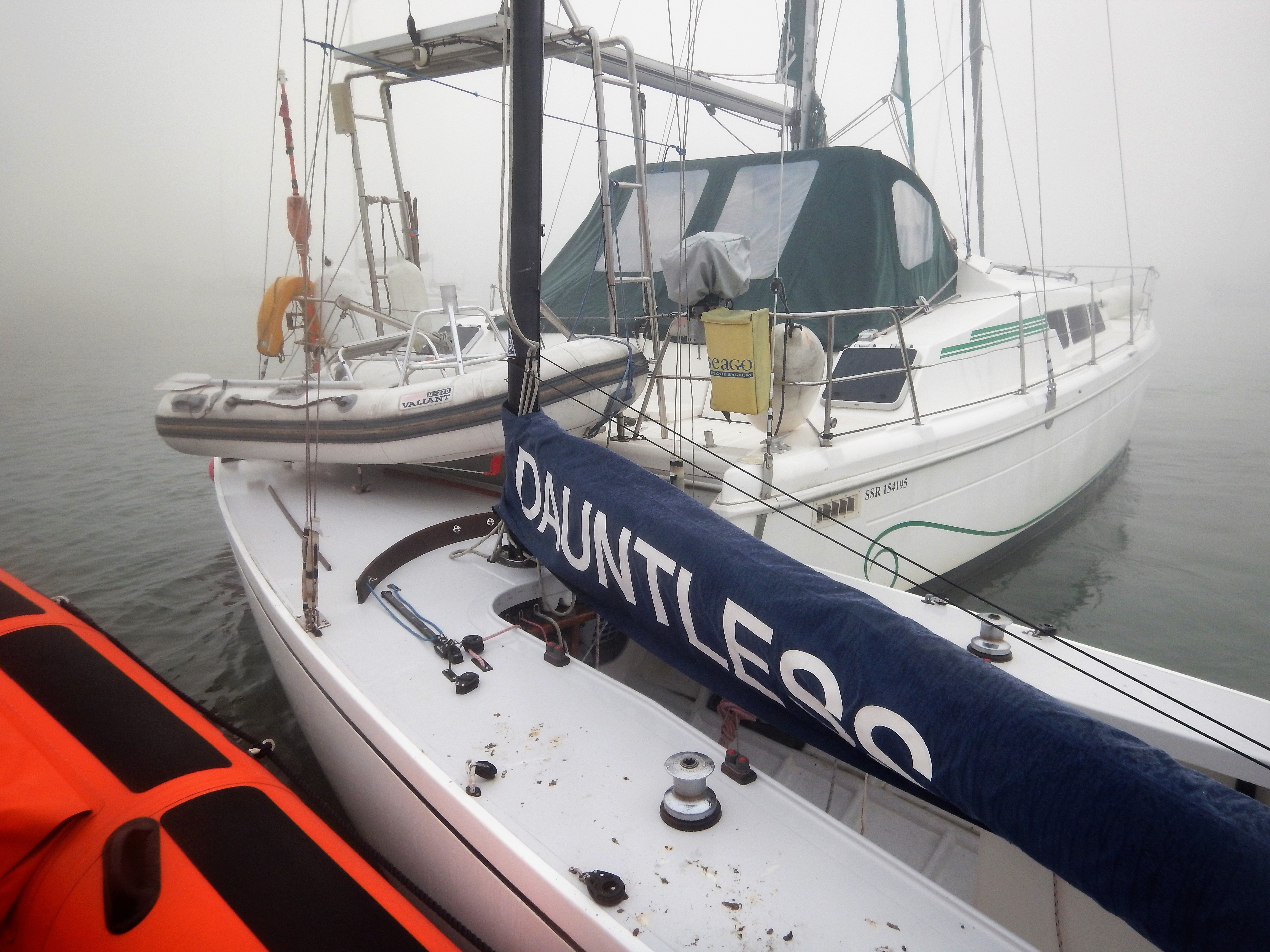 One of the Daring Class yachts, Dauntless, hard against the stern of the catamaran