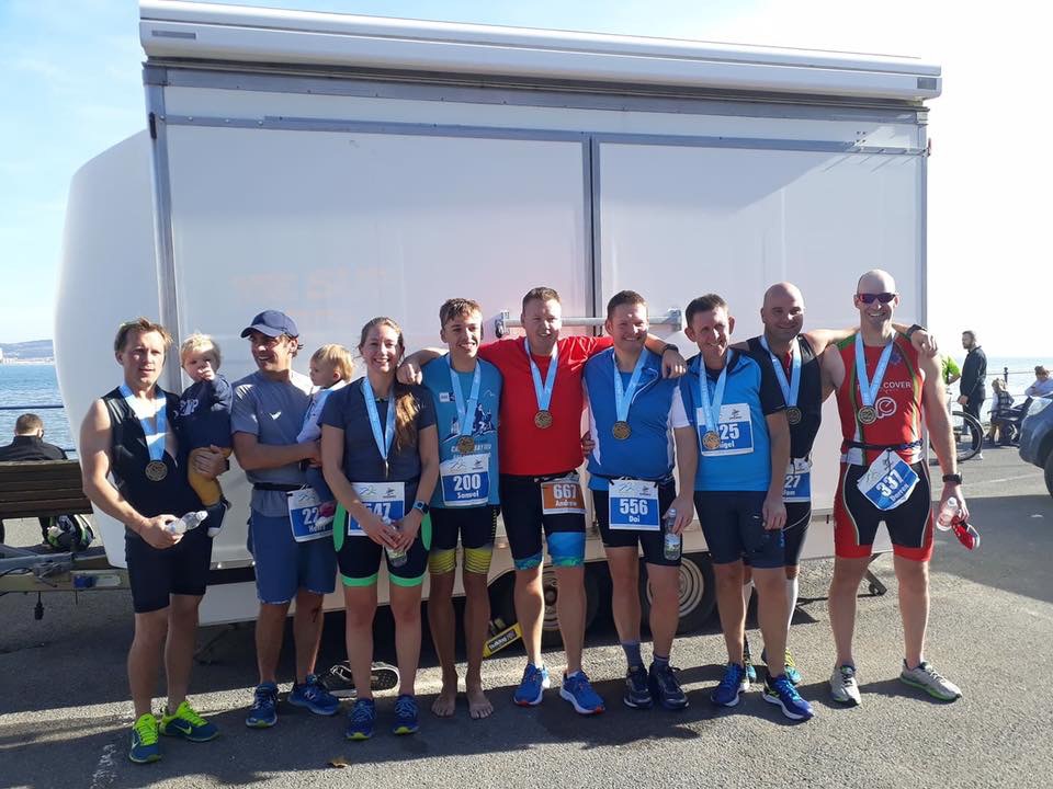 Crew members gather with family and crew cadet Sam Ace who also completed the Triathlon