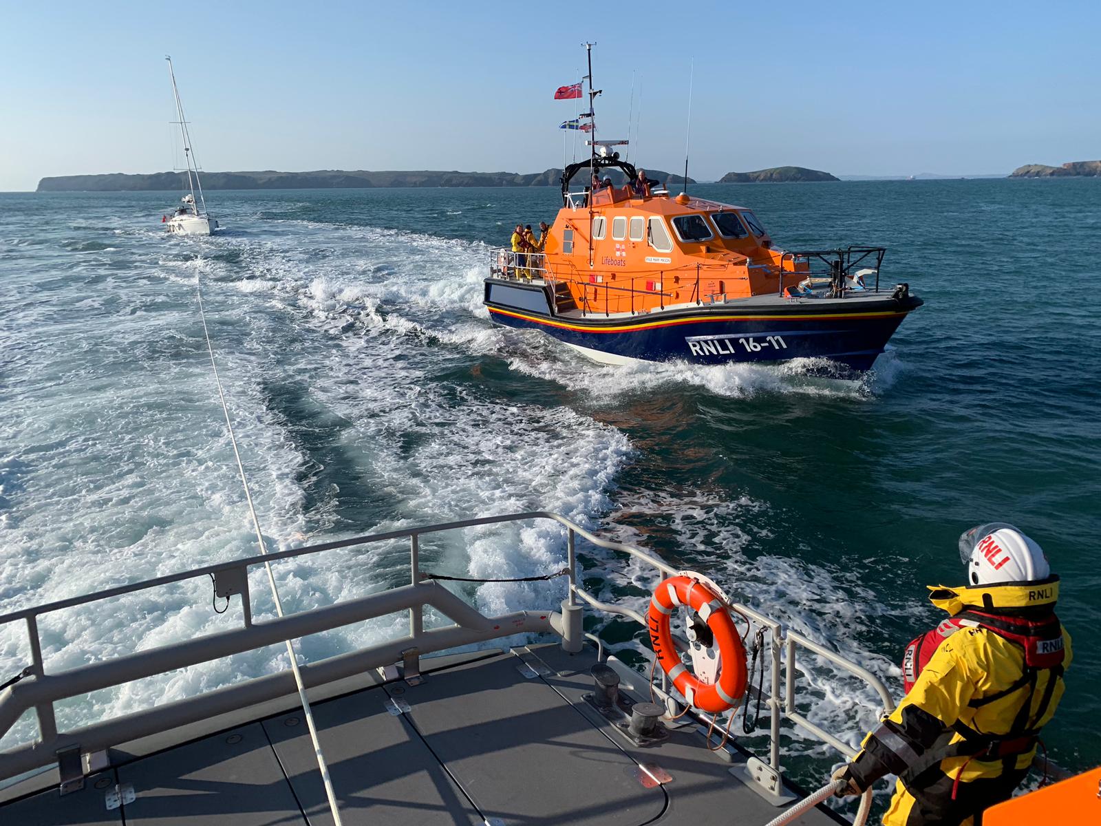 Broken down yacht is towed by St Davids RNLI with Angle RNLI ready to to take over the tow.