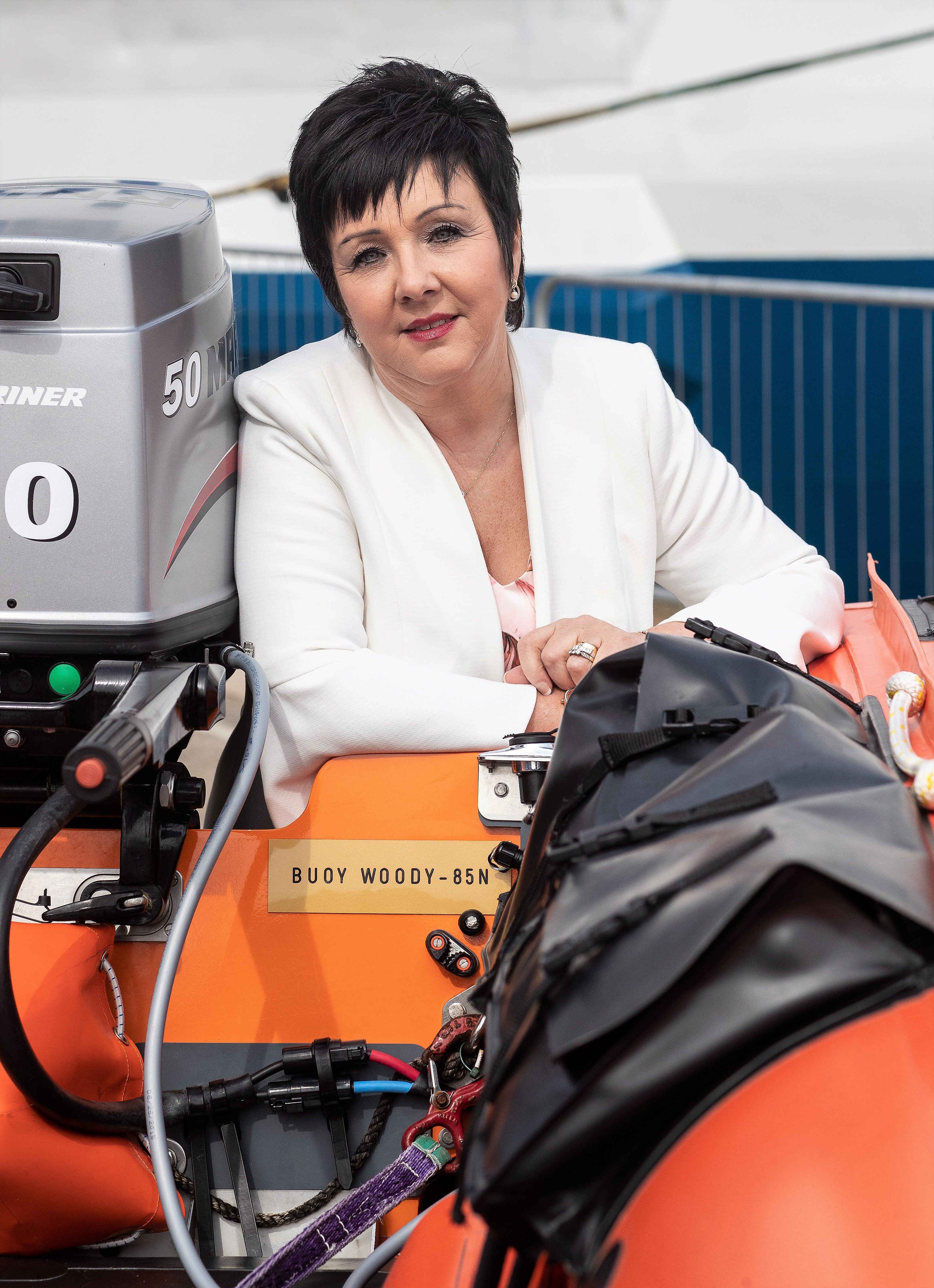 Mrs Audrey Wood alongside Aberdeen inshore lifeboat ‘Buoy Woody – 85N’ showing the plaque bearing the lifeboat’s name