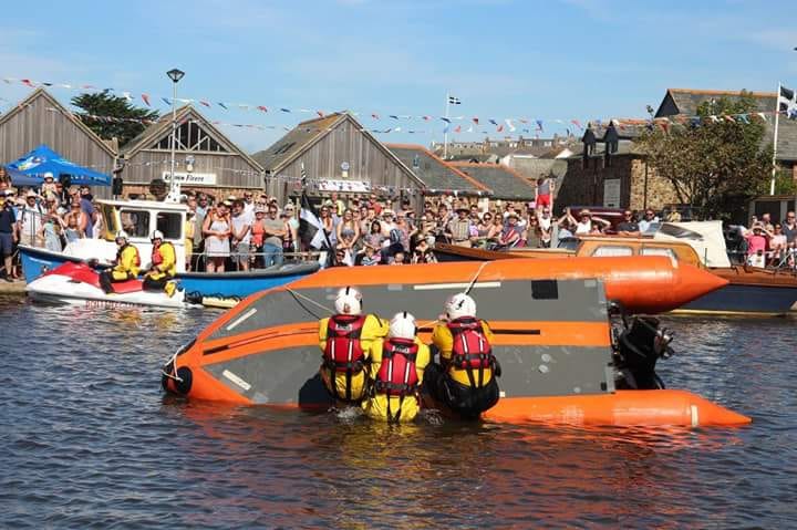 Bude volunteer lifeboat crew demonstrating righting a capsized vessel in front of crowds on Bude canal