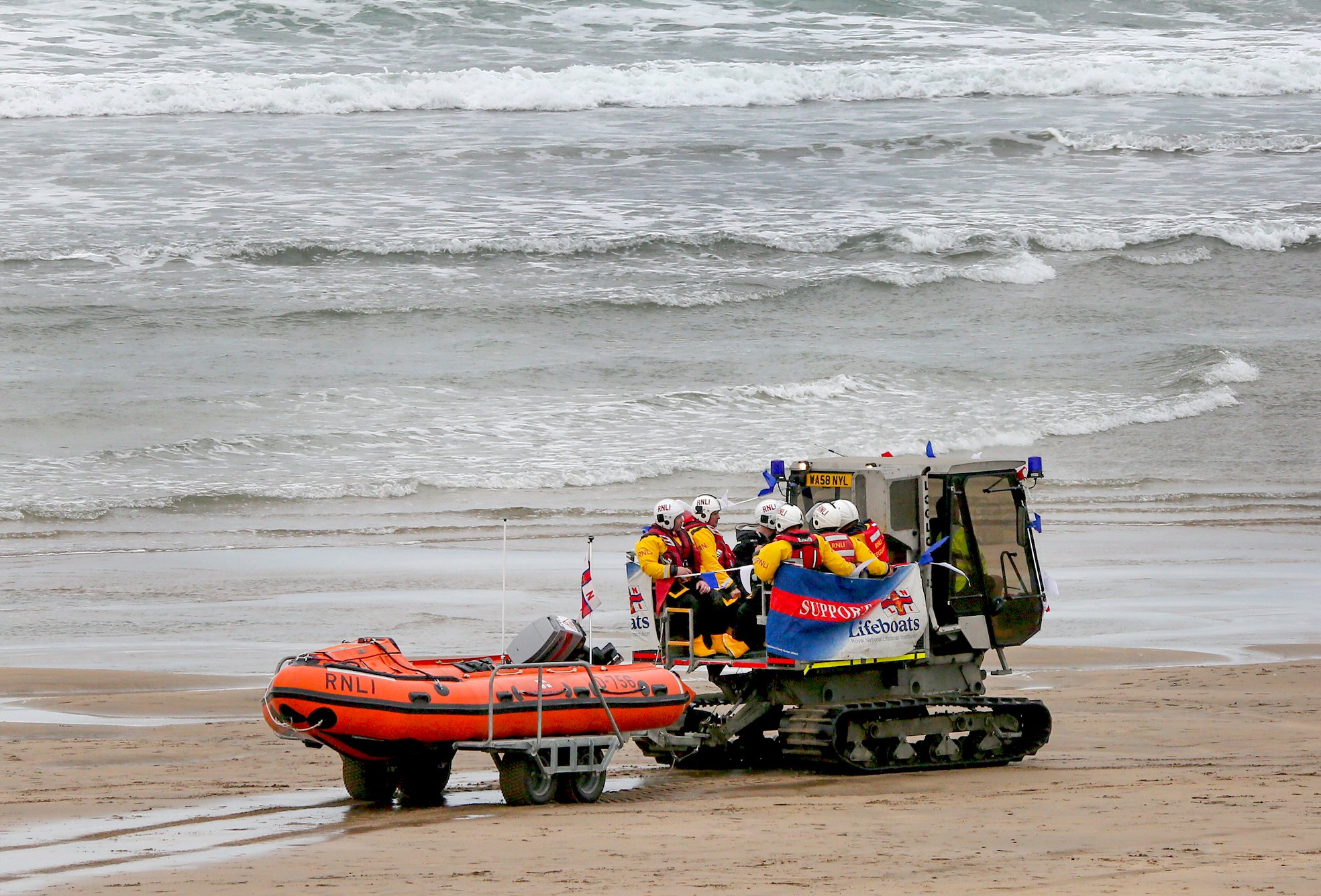 RNLI Bude volunteer crew on Summerleaze beach before launching for a demonstration on Lifeboat Day