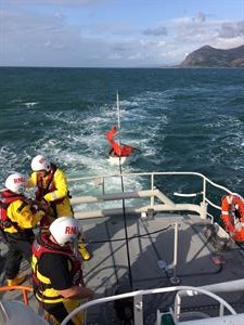 Porthdinllaen Lifeboat towing sailing dinghy ashore after rescue