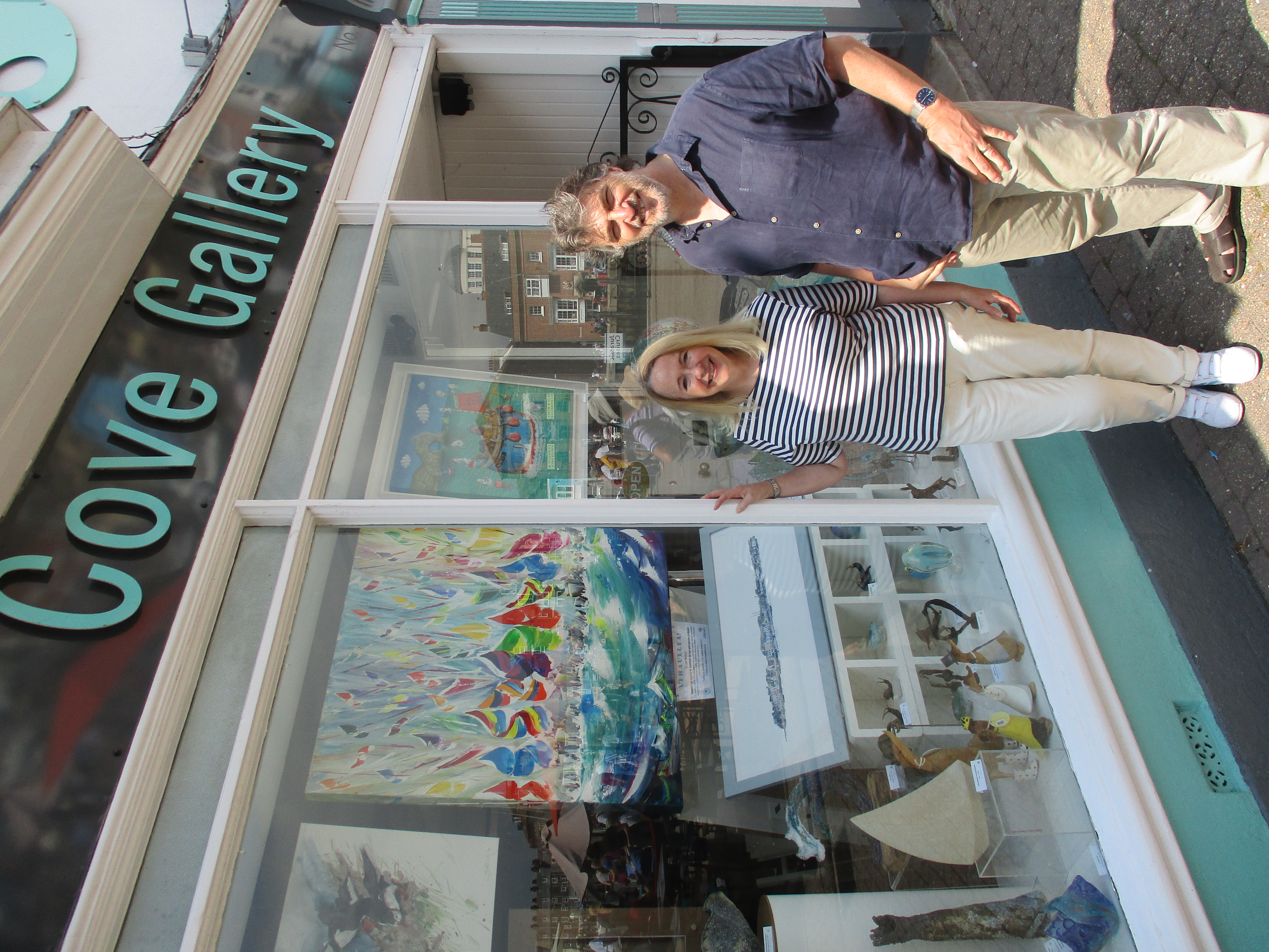Artist Jan Nelson and Cove Gallery Paul Mooney outside the Cove Gallery with the painting on display in the window.