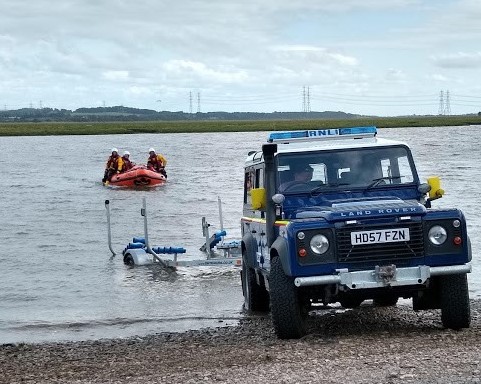 RNLI volunteers prepare to recover the inshore lifeboat
