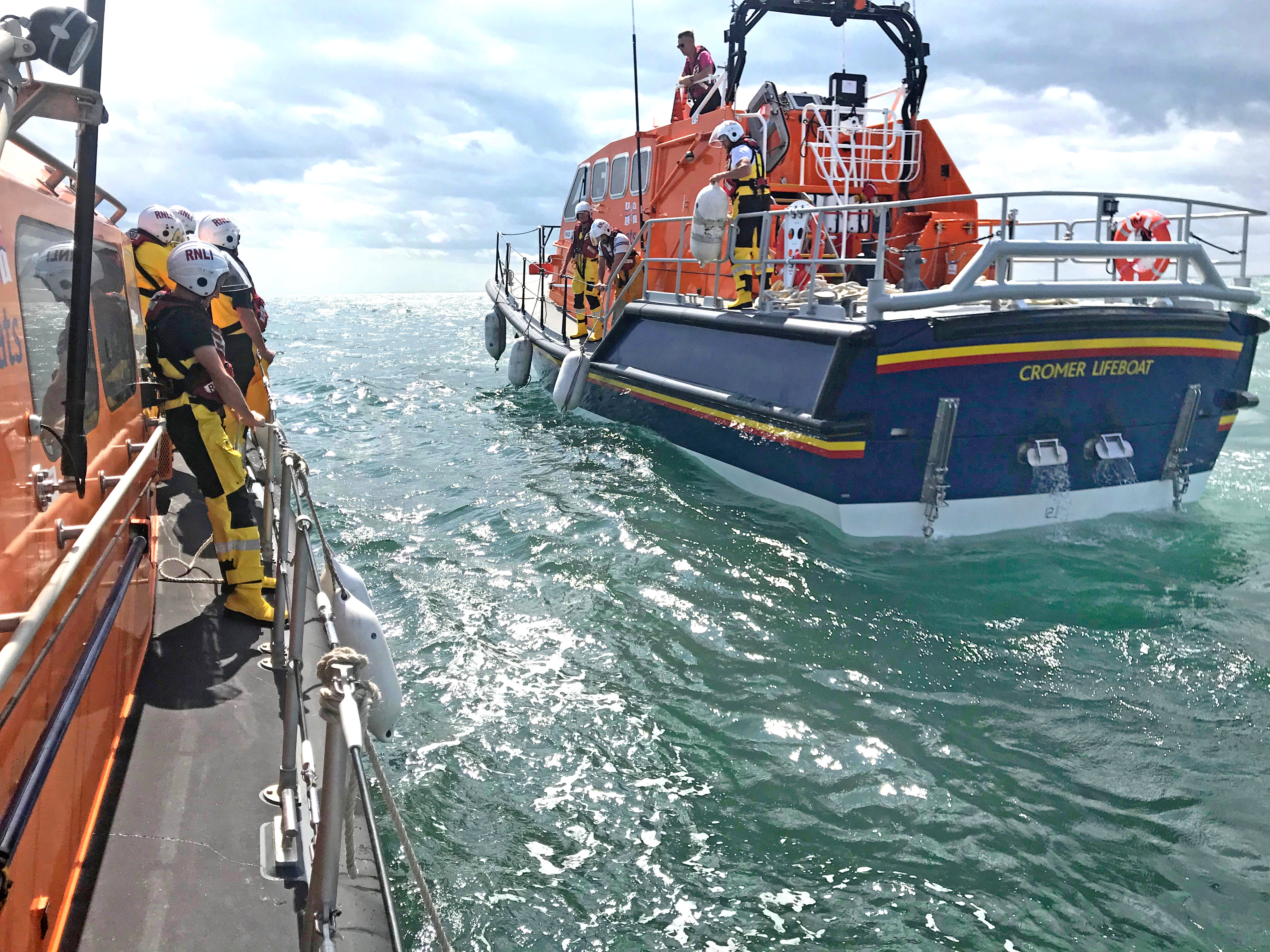 Lowestoft and Cromer RNLI lifeboats prepare to transfer a crew member