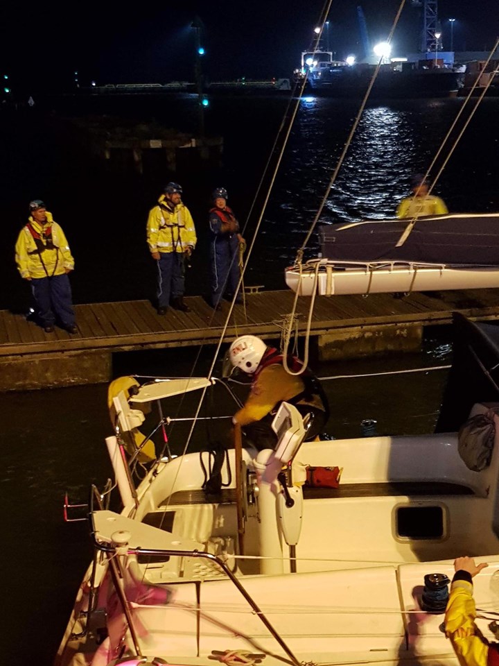 Lifeboat crew securing stricken vessel and Coastguards on hand to greet