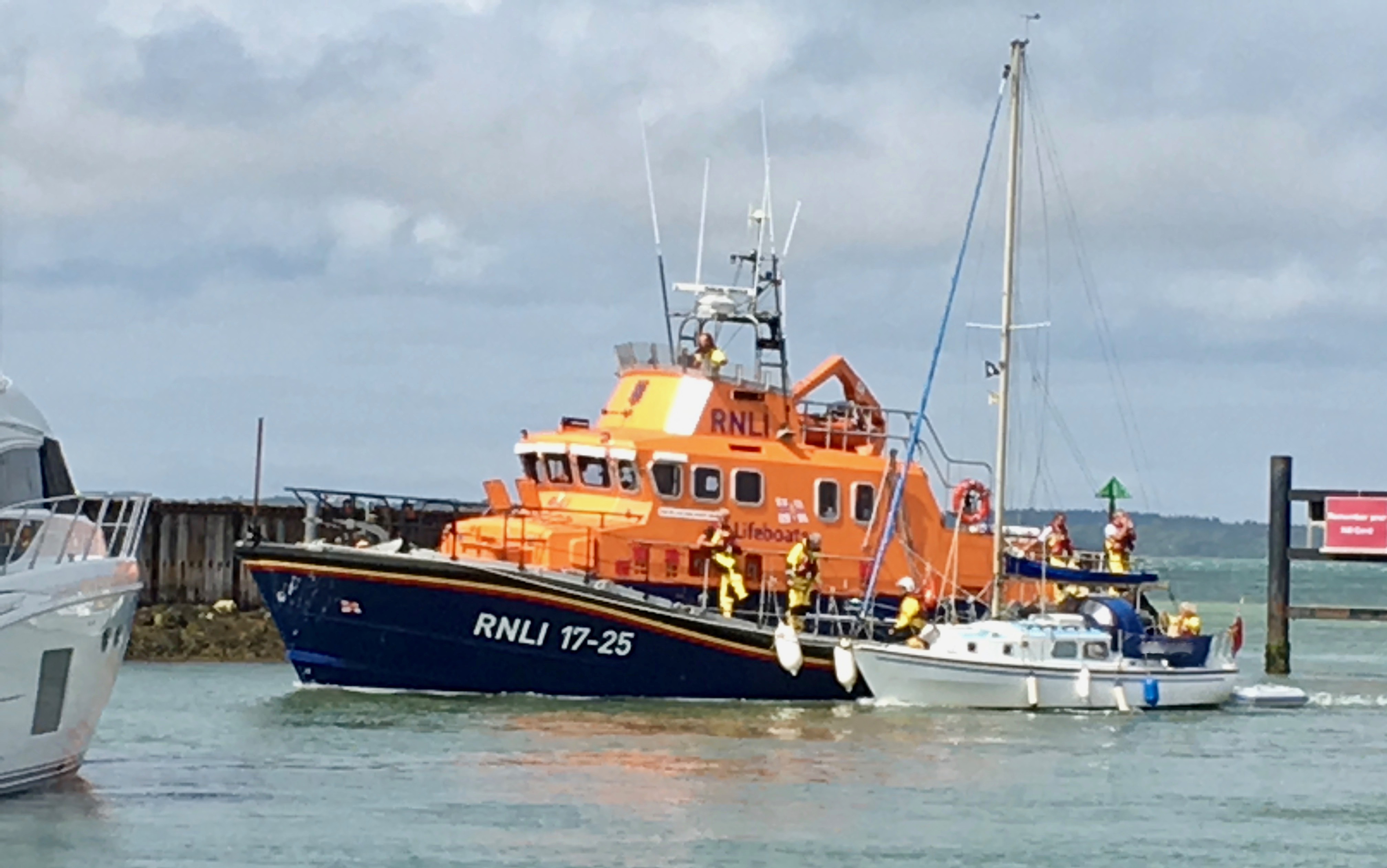 The 28ft is under tow on the port side of Yarmouth's severn class all weather lifeboat in the entrance to Yarmouth Harbour.