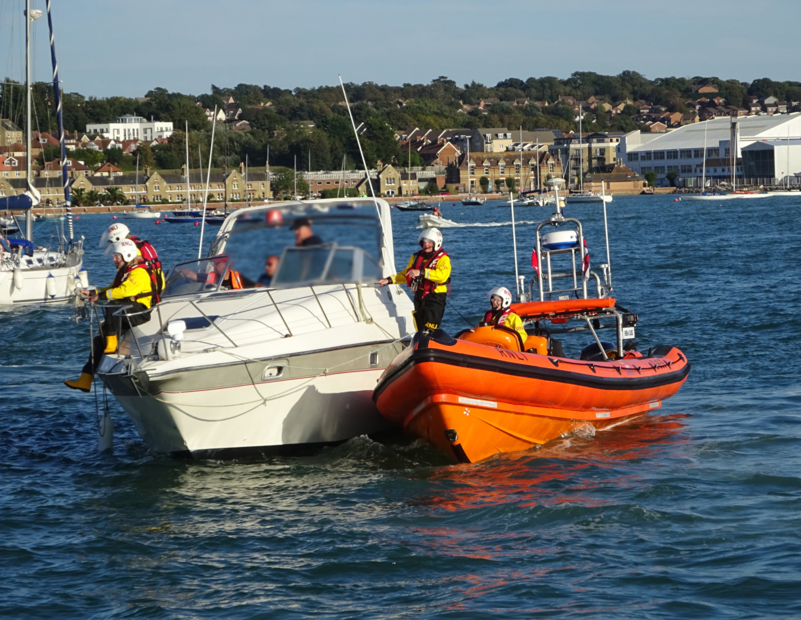 The lifeboat prepares to complete its alongside tow, in Cowes Harbour.
