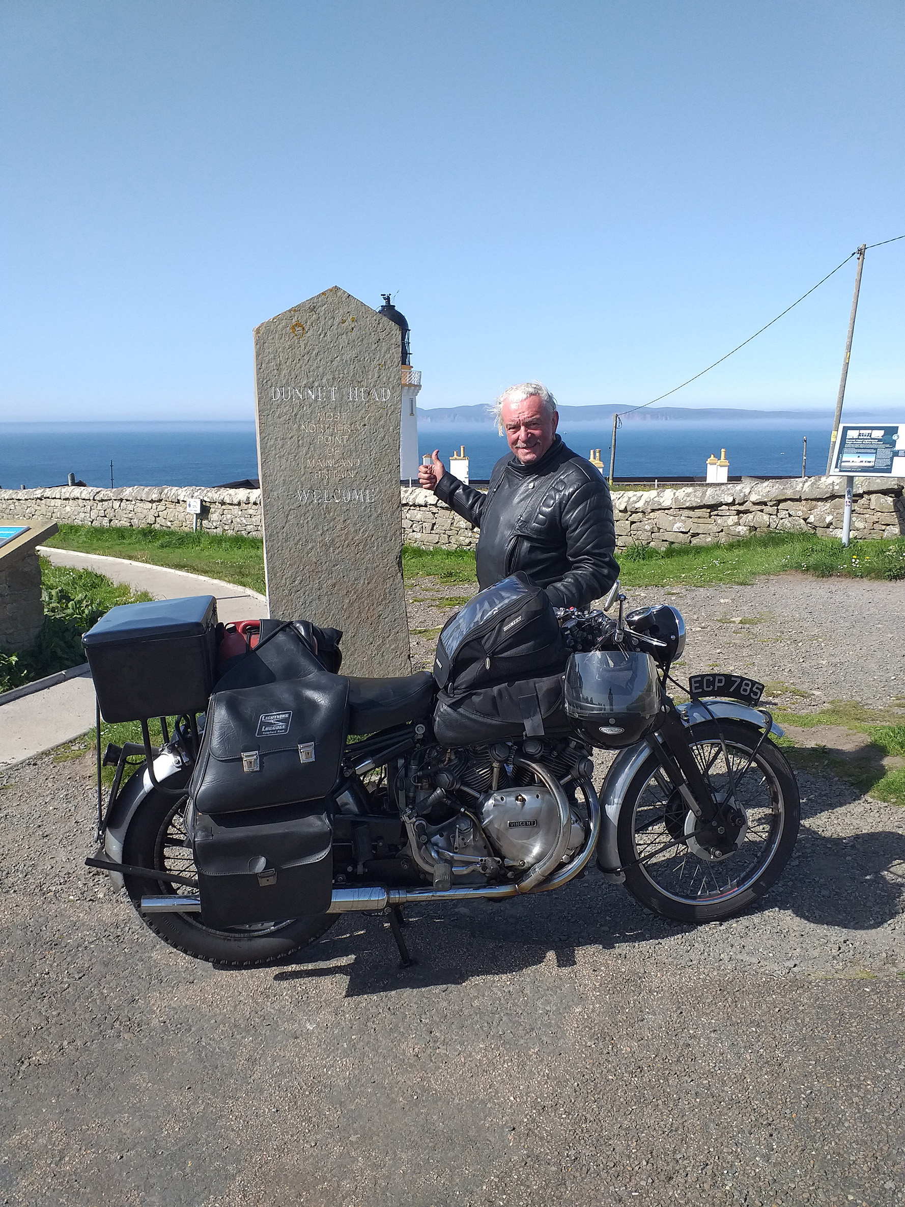 John Newson and his motorbike next to a stone indicating that Dunnet Head is the furthest point north on the UK mainland