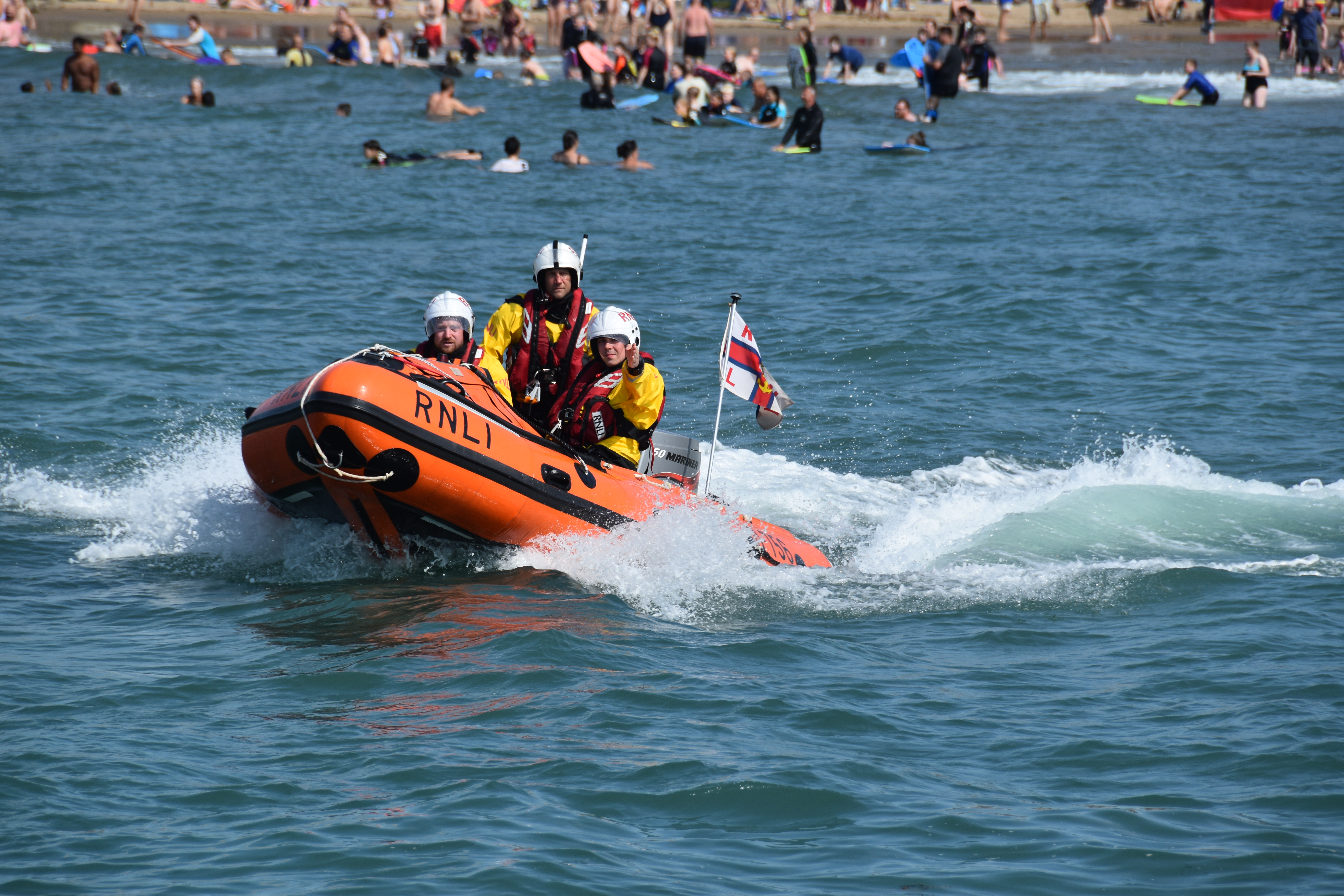 Three volunteer crew members onboard the D class lifeboat called George Bird on Lifeboat Day