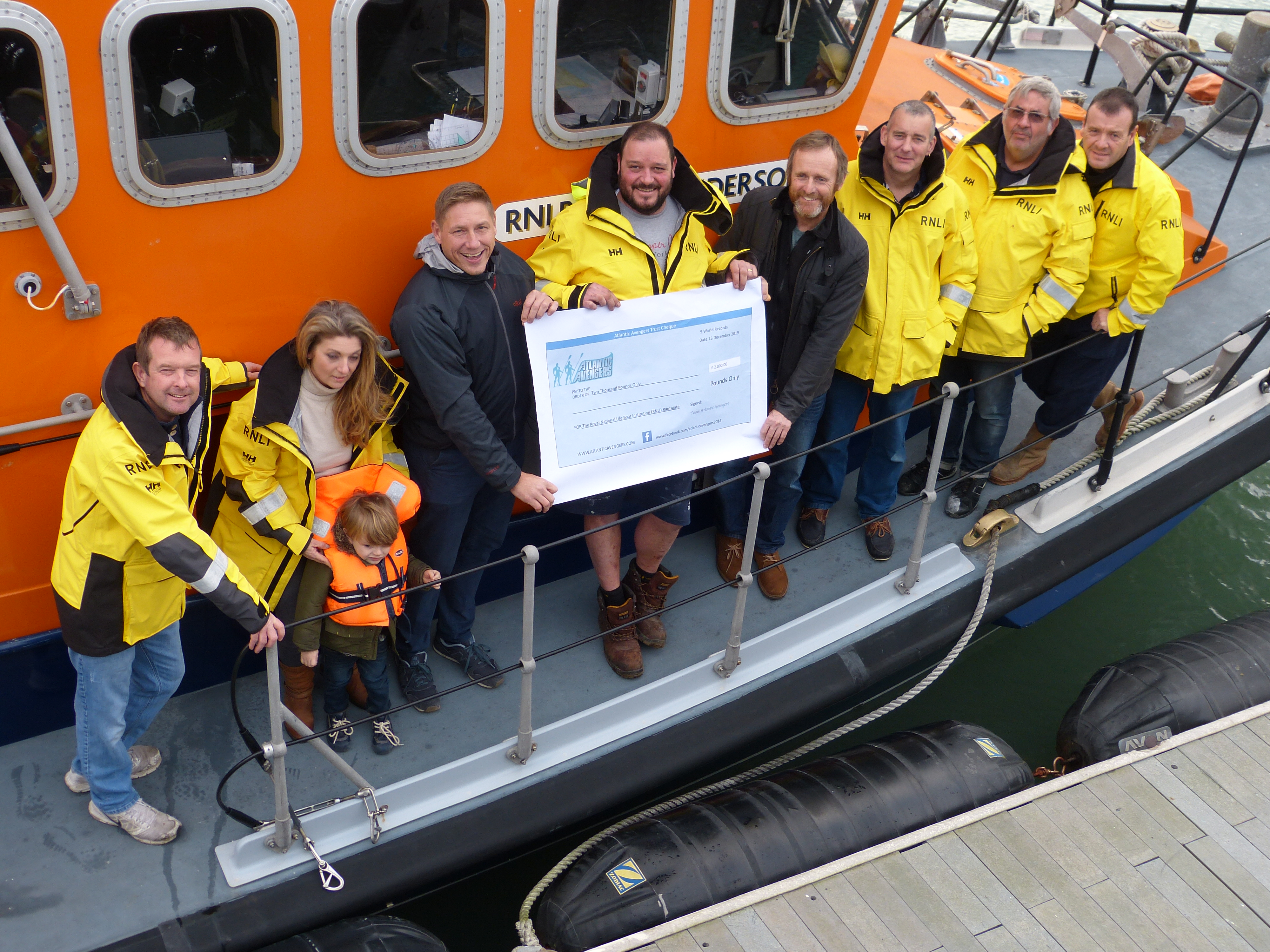 The crew onboard the allweather boat being presented with a cheque
