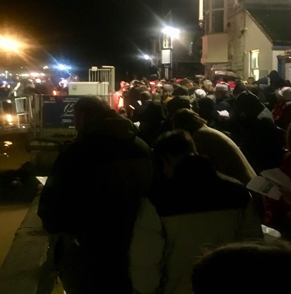 The crowd singing carols